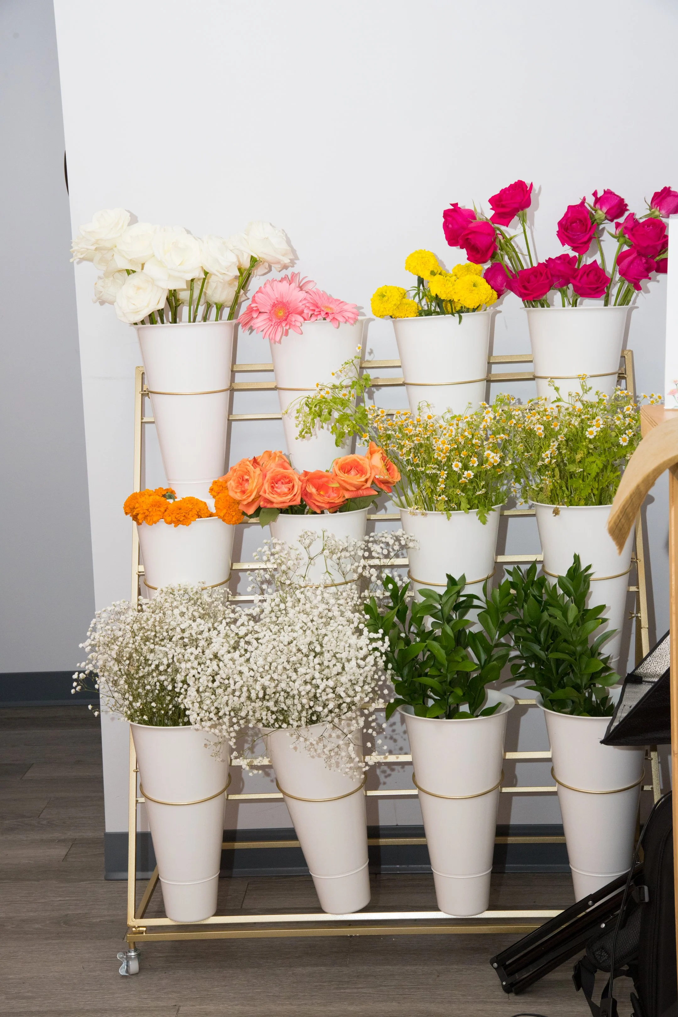 Bloom bar assorted flowers in a tiered stand for picnic decoration by Picnics By Peace