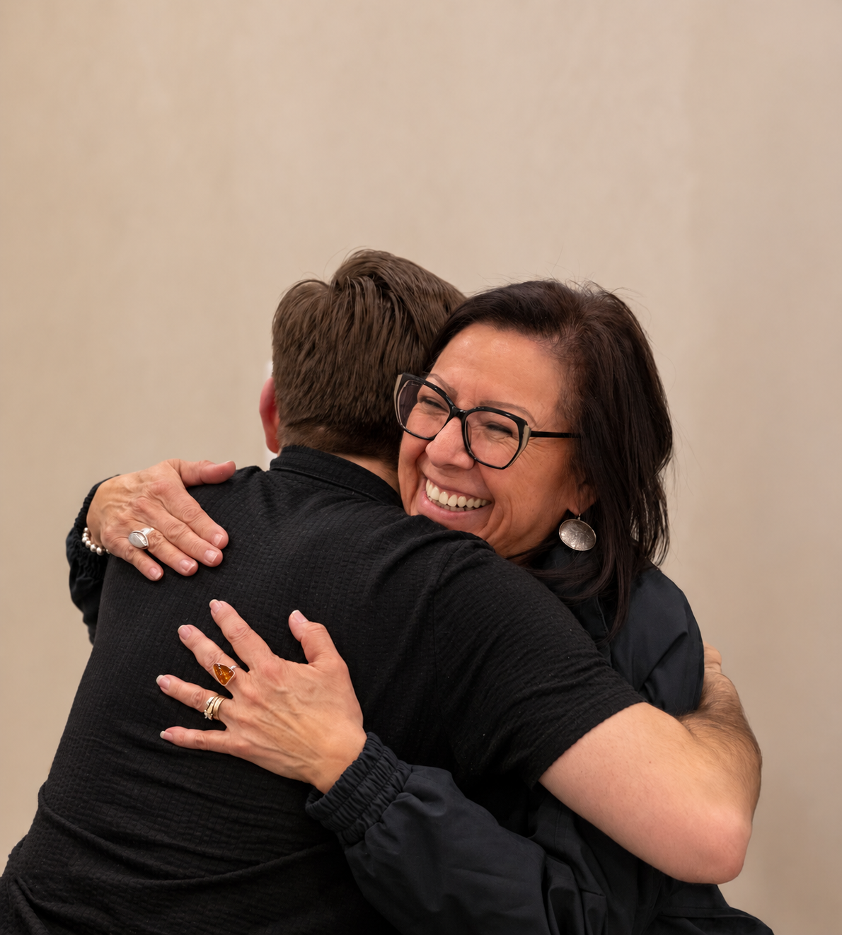Two people embracing, one smiling warmly