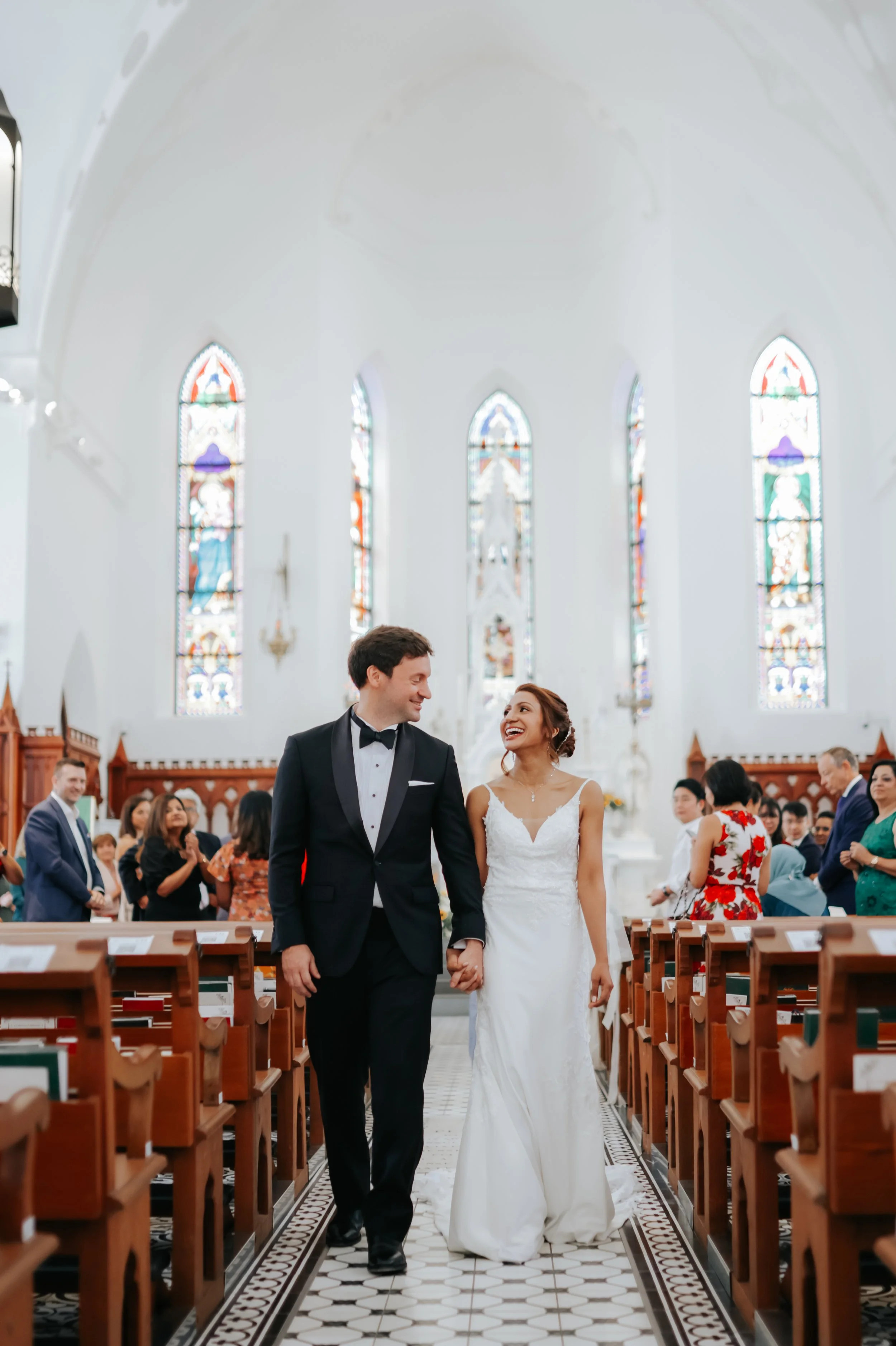 Light and airy actual day church wedding photoshoot at Church of Saints Peter and Paul, the couple walks down the aisles in front of the lectern captured by Ash for Breadandbutterworks.