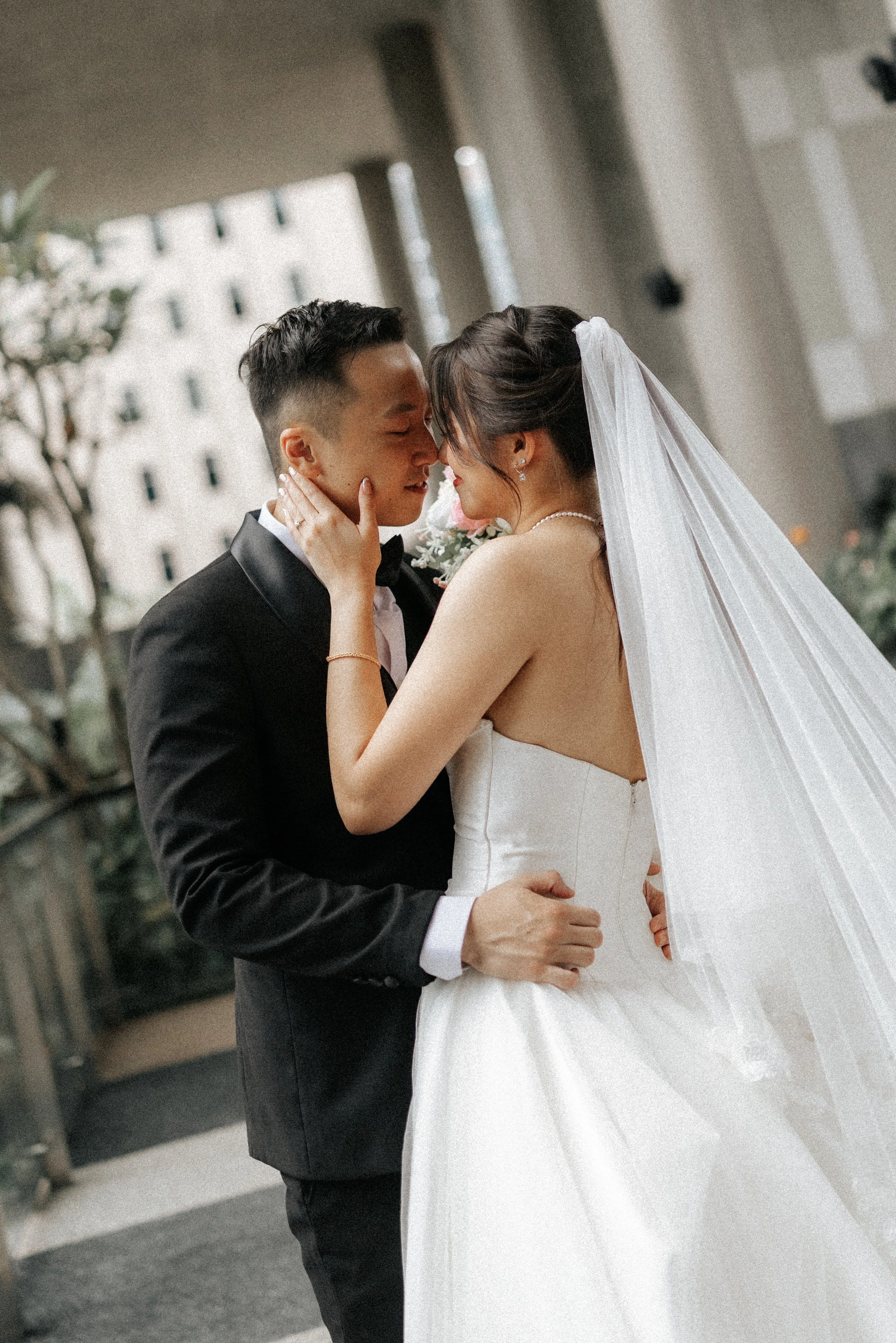 Romantic actual day wedding photography of the couple posing at PARKROYAL Pickering, captured by Breadandbutterworks in a soft and heartfelt style.