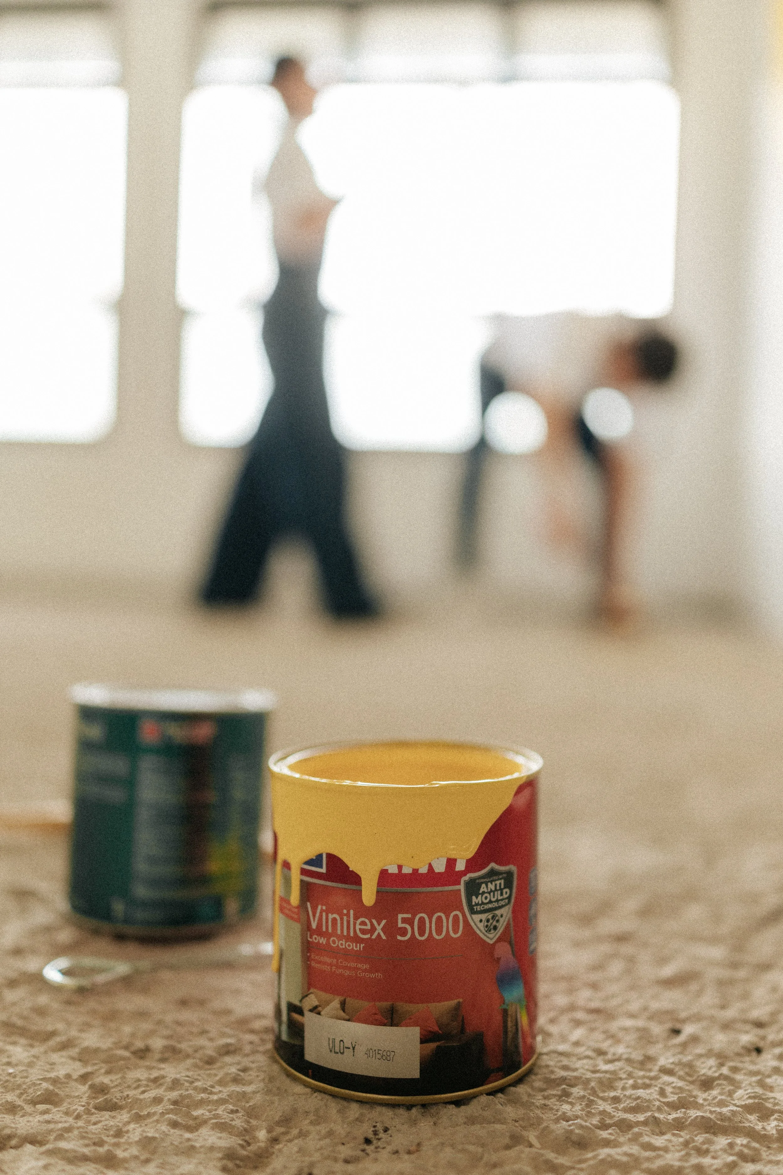 Creative shot of a home pre-wedding photoshoot of a couple painting their marital home together, captured by Breadandbutterworks in a light, airy and heartfelt style.