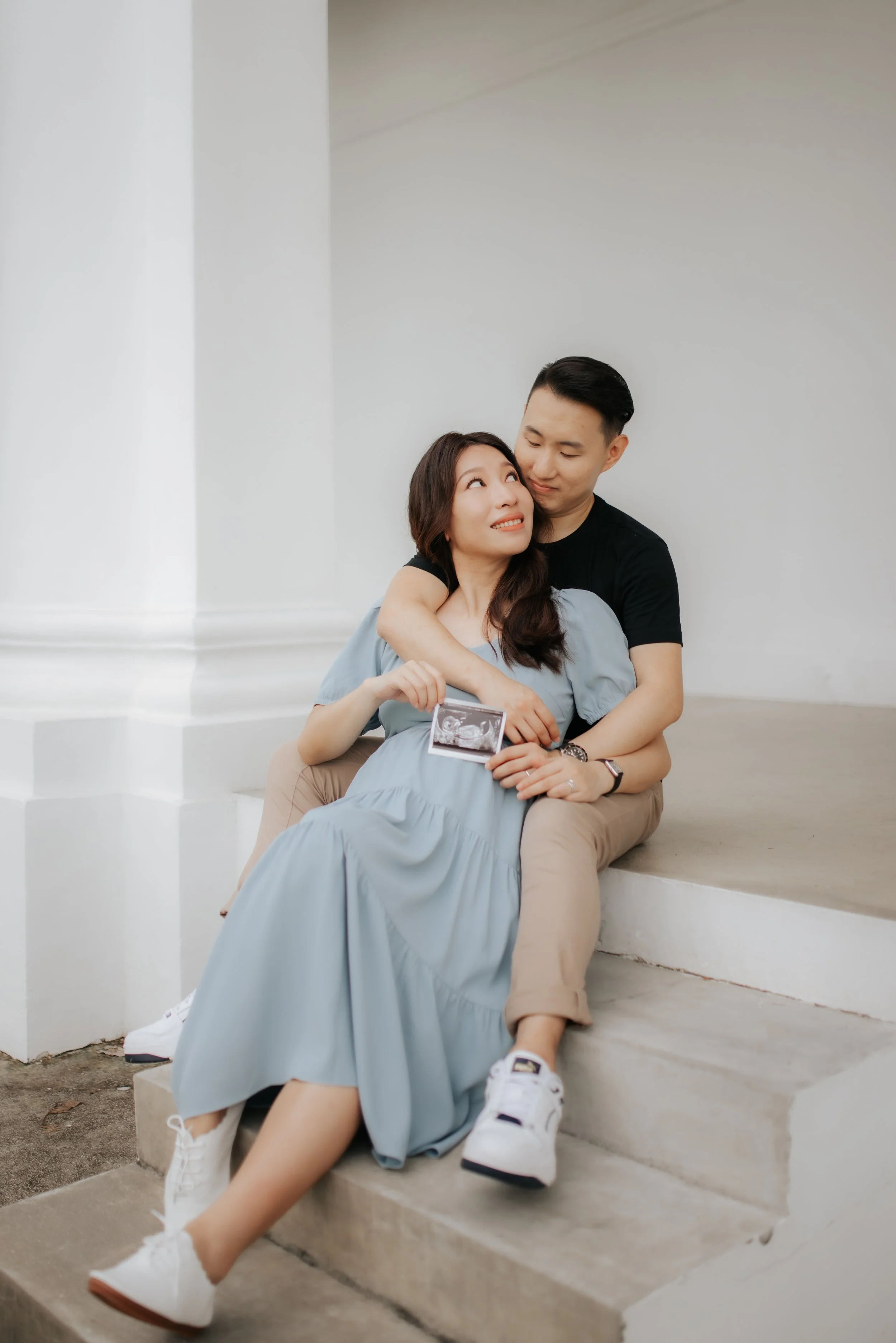 Parents-to-be share an intimate look as they pose for their maternity shoot, captured by Breadandbutterworks in a soft and heartfelt style.