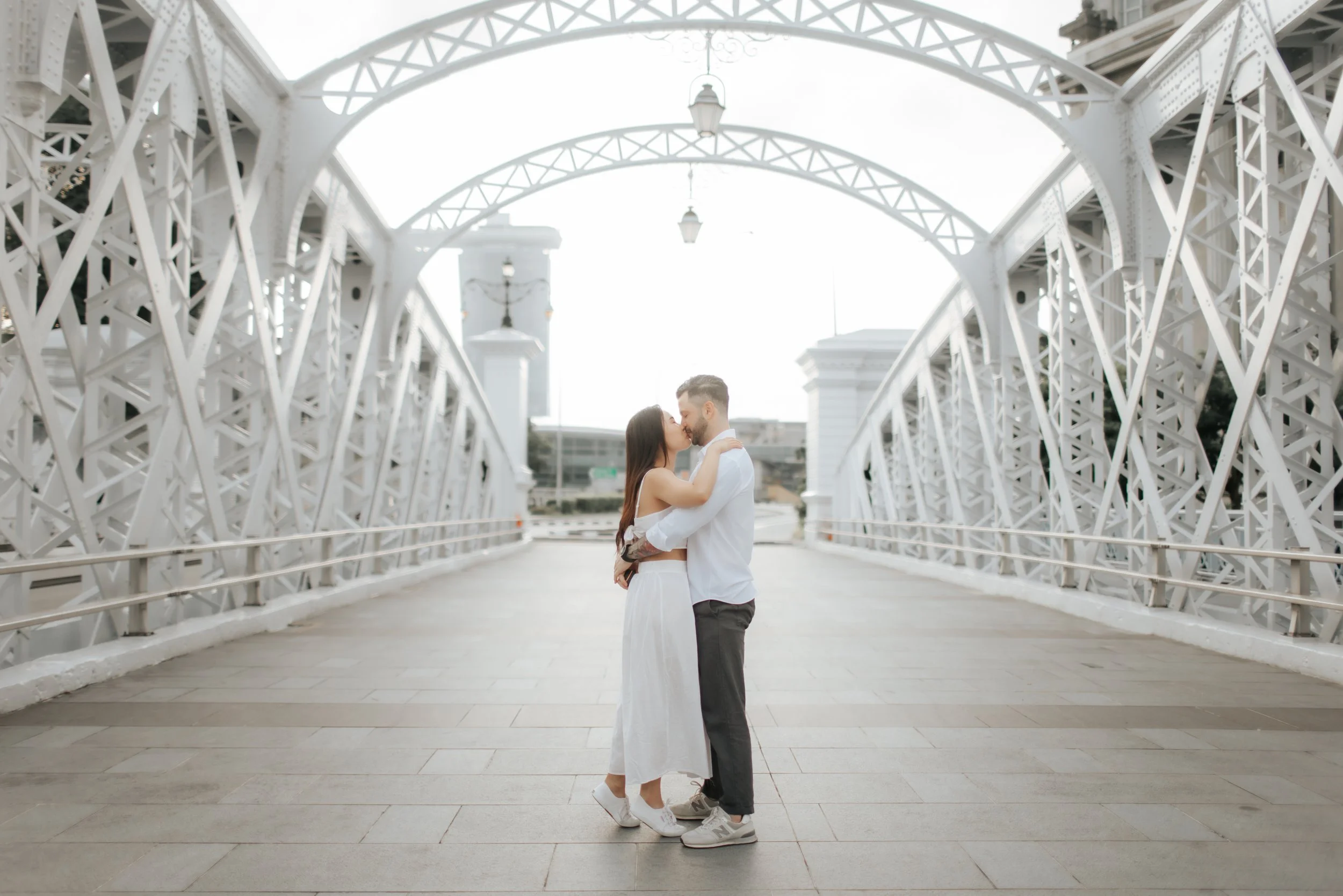 Light and airy proposal photoshoot at Anderson Bridge, the couple poses on the bridge. Captured by Arielle for Breadandbutterworks.