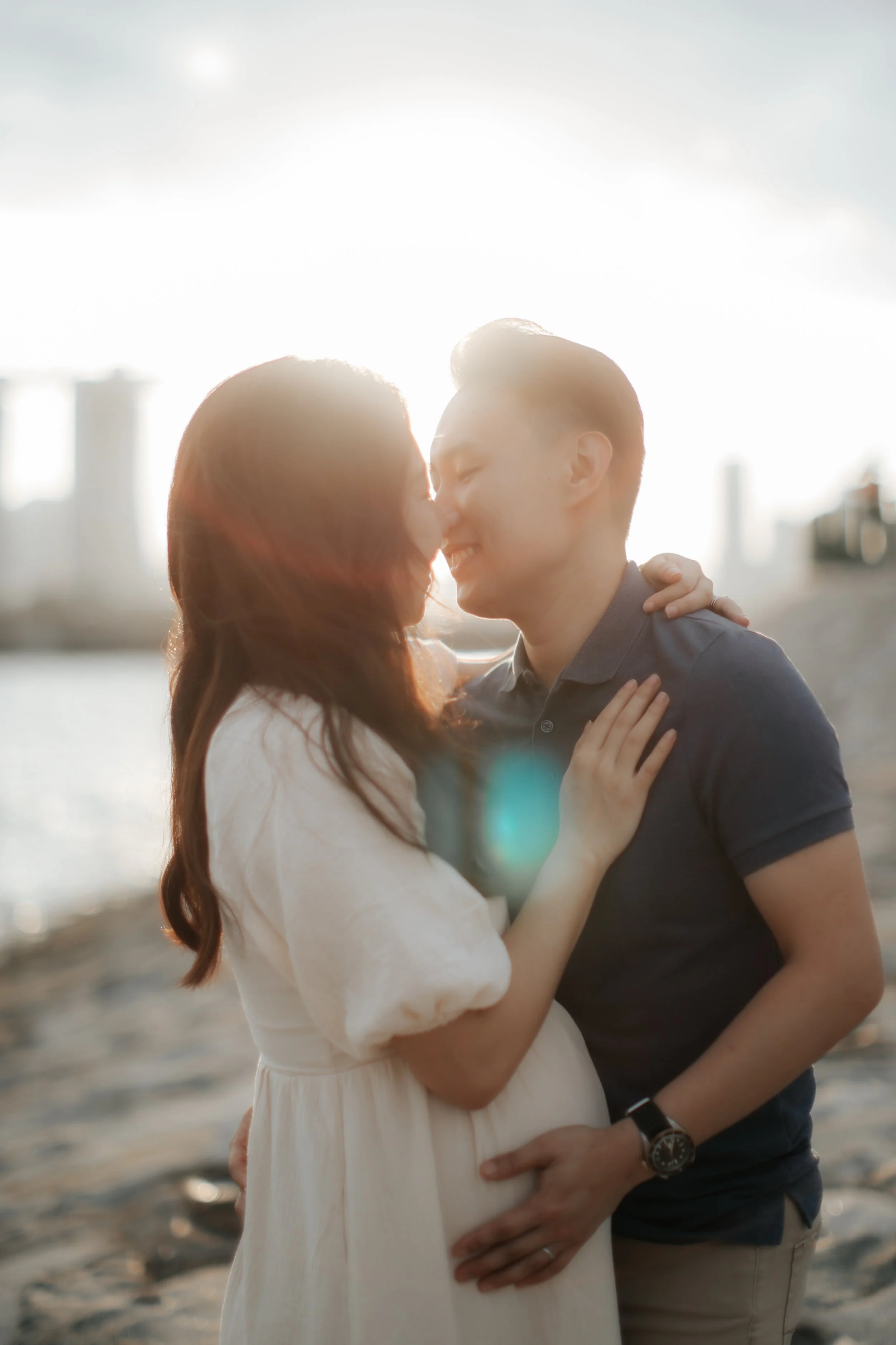 A couple shares an intimate moment during their maternity shoot, captured by Breadandbutterworks in a soft and heartfelt style.