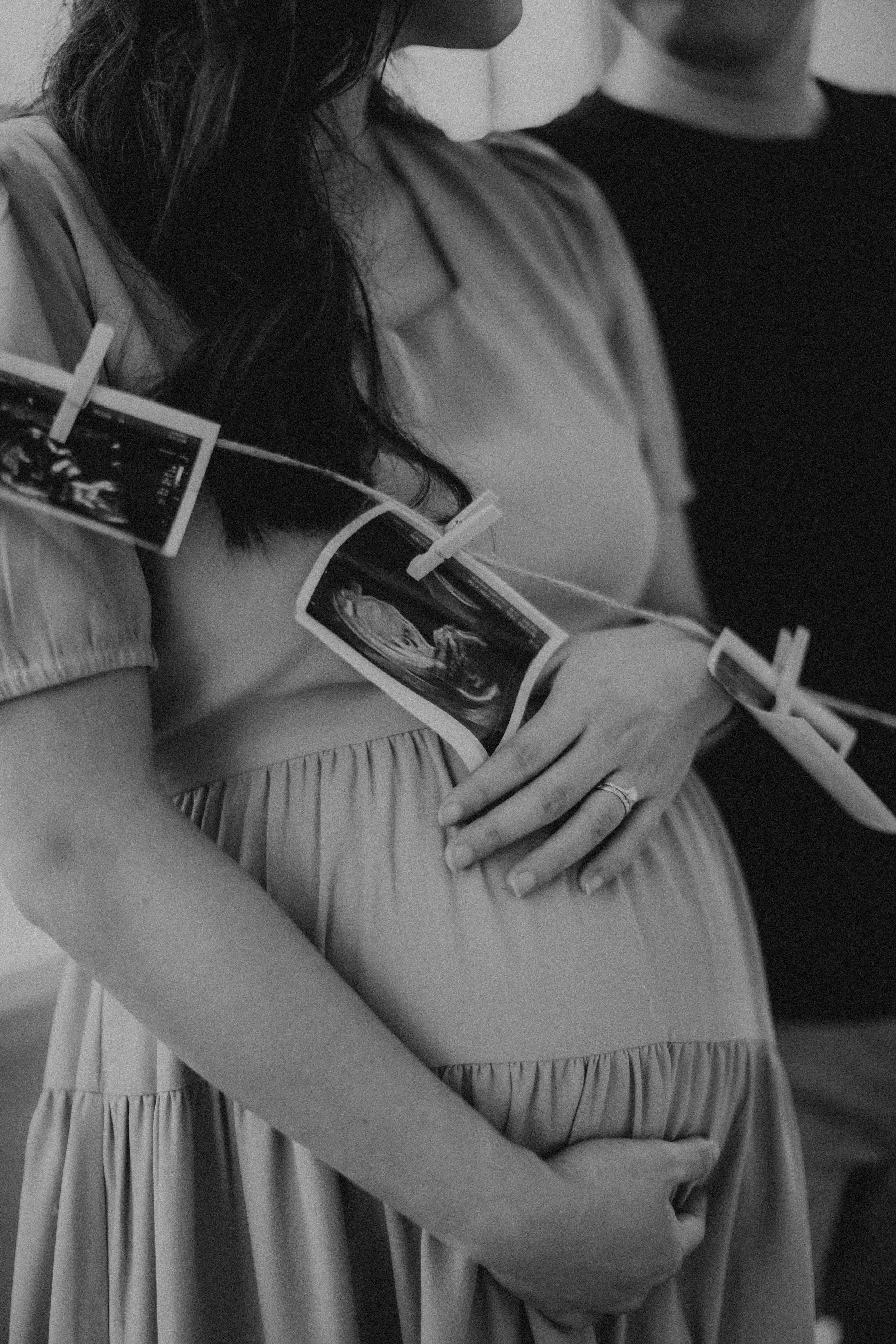 Artistic black and white detail photo of a couple during their maternity shoot, captured by Breadandbutterworks.