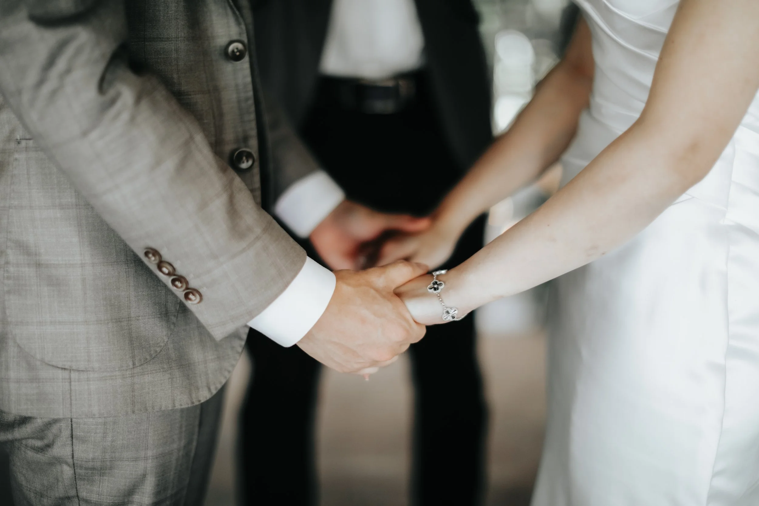 Light and airy close-up actual day wedding photoshoot at Canopy HortPark, the couple holds each other's hands as their share their vows. Captured by Arielle from Breadandbutterworks.