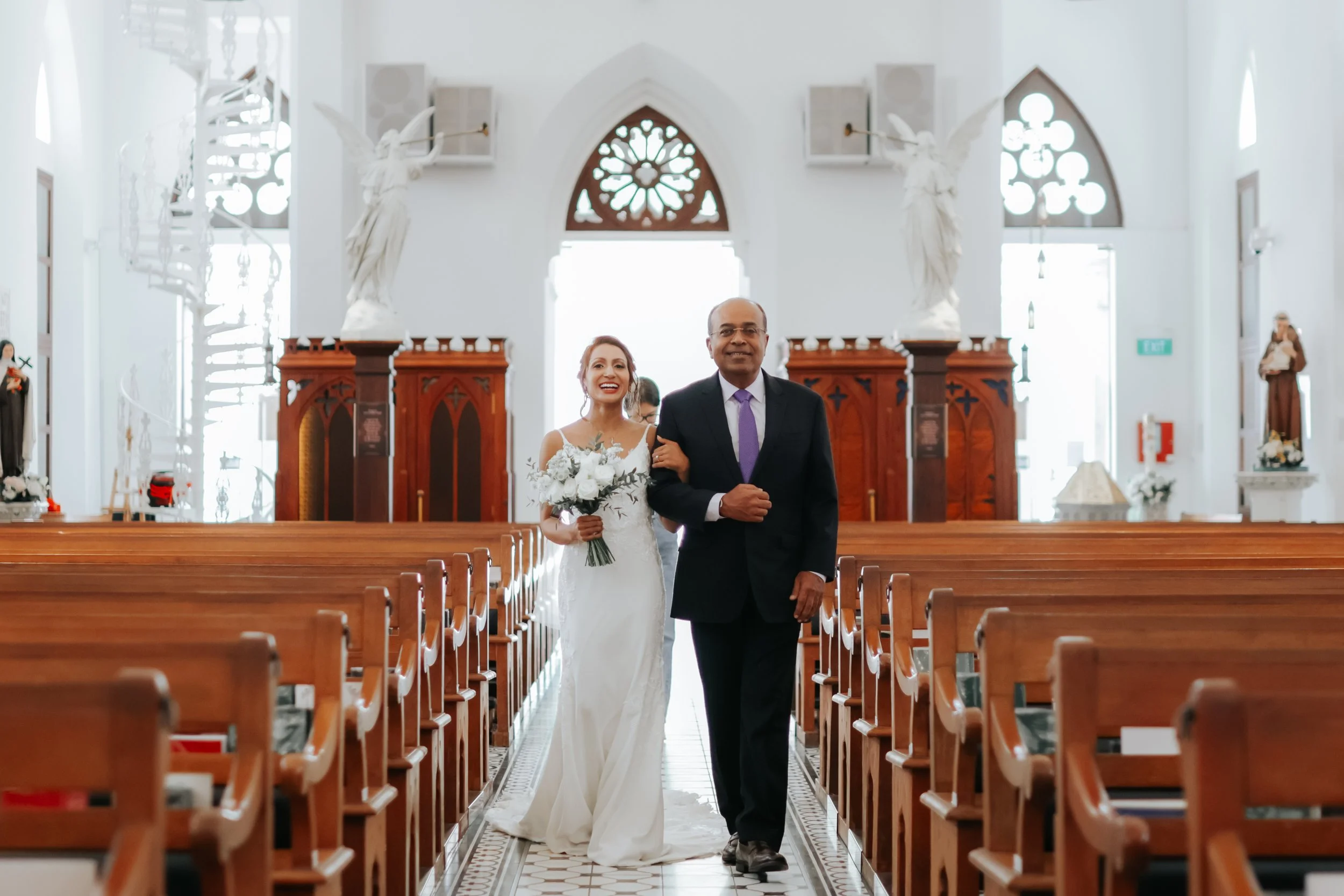 Light and airy actual day church wedding photoshoot at Church of Saints Peter and Paul, this scene of bride's father walking her down the aisle was captured by Ash for Breadandbutterworks.