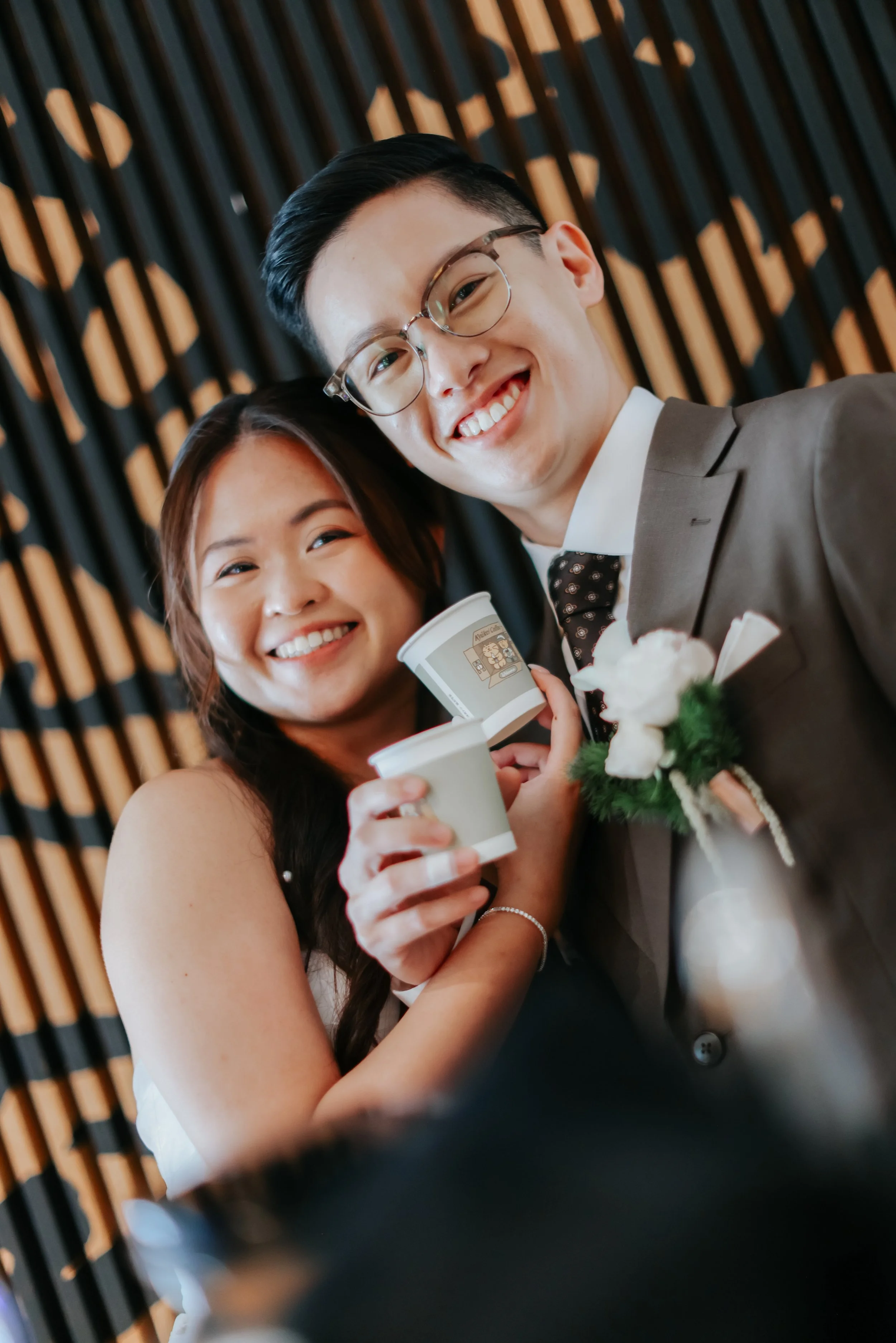 The wedded couple who are both coffee lovers pose with their cups of espresso during their actual day wedding. Photographed by Breadandbutterworks.