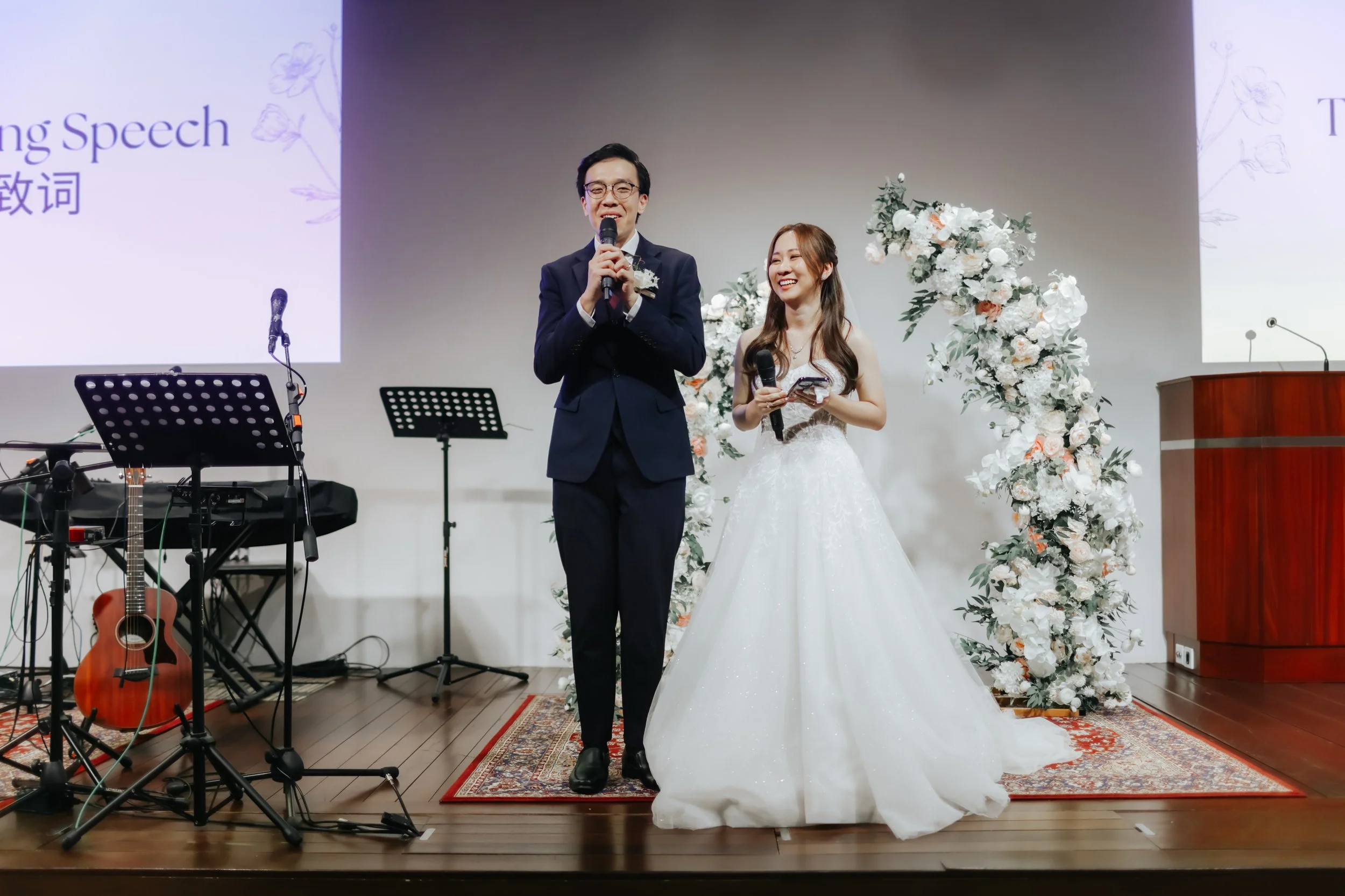 Light and airy actual day photoshoot of a couple on stage at Bukit Panjang Church, they address their guests with a heartfelt speech. Captured by Arielle for Breadandbutterworks.