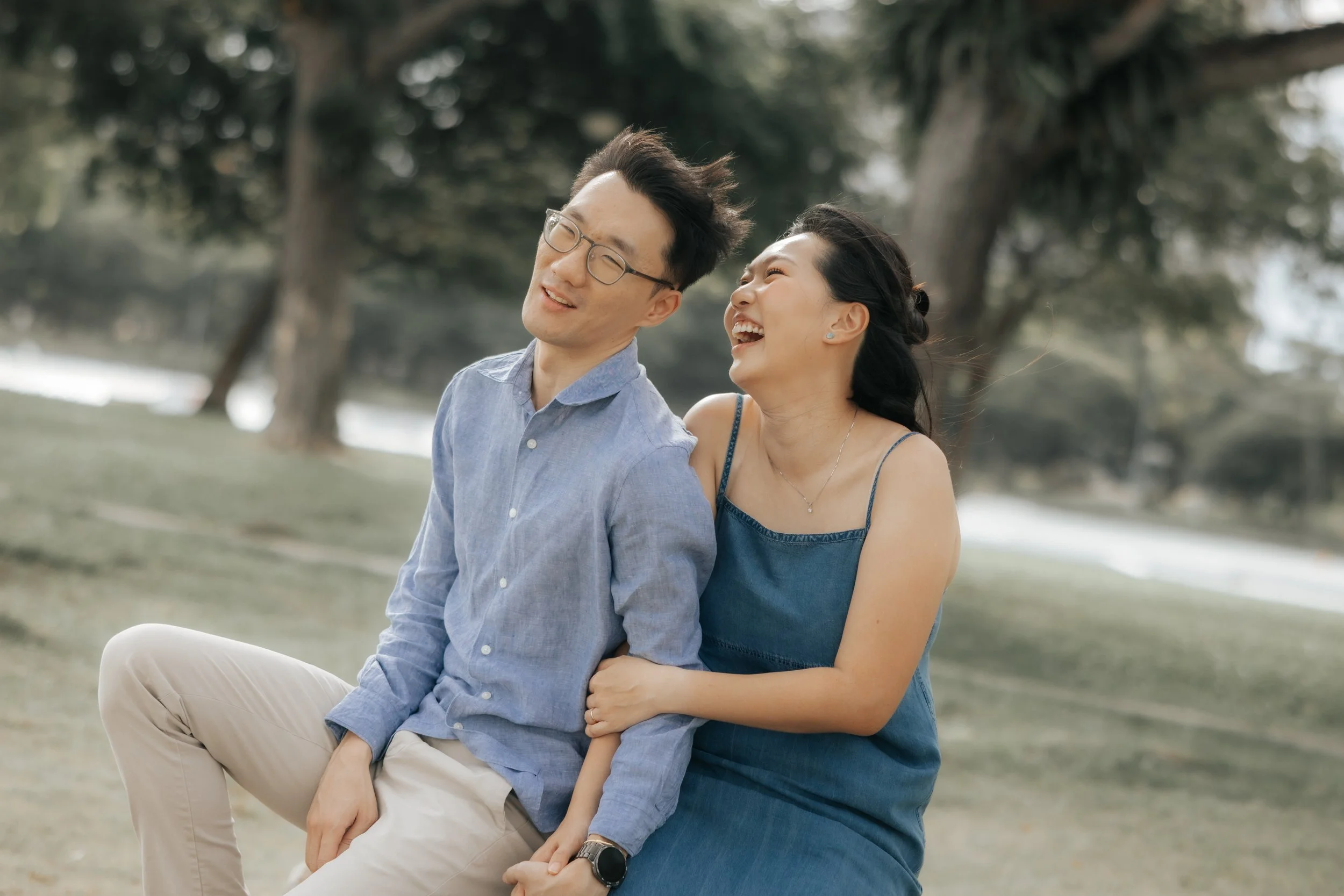 Playful pre-wedding photo of a couple sharing a moment at East Coast Park, captured by Breadandbutterworks in a soft and heartfelt style.