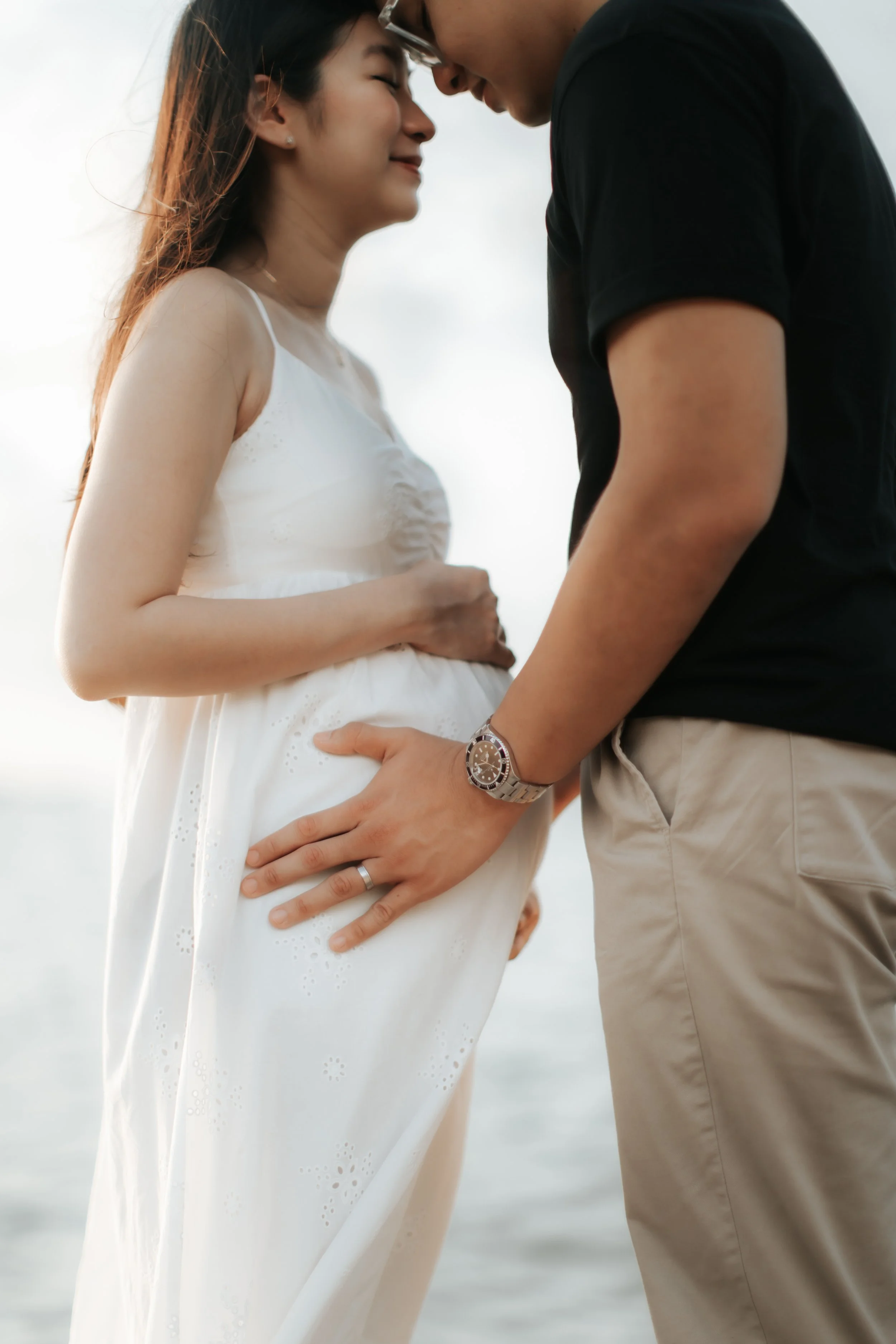Intimate close-up maternity shoot at sunset at East Coast Park in Singapore, captured by Arielle for Breadandbutterworks.