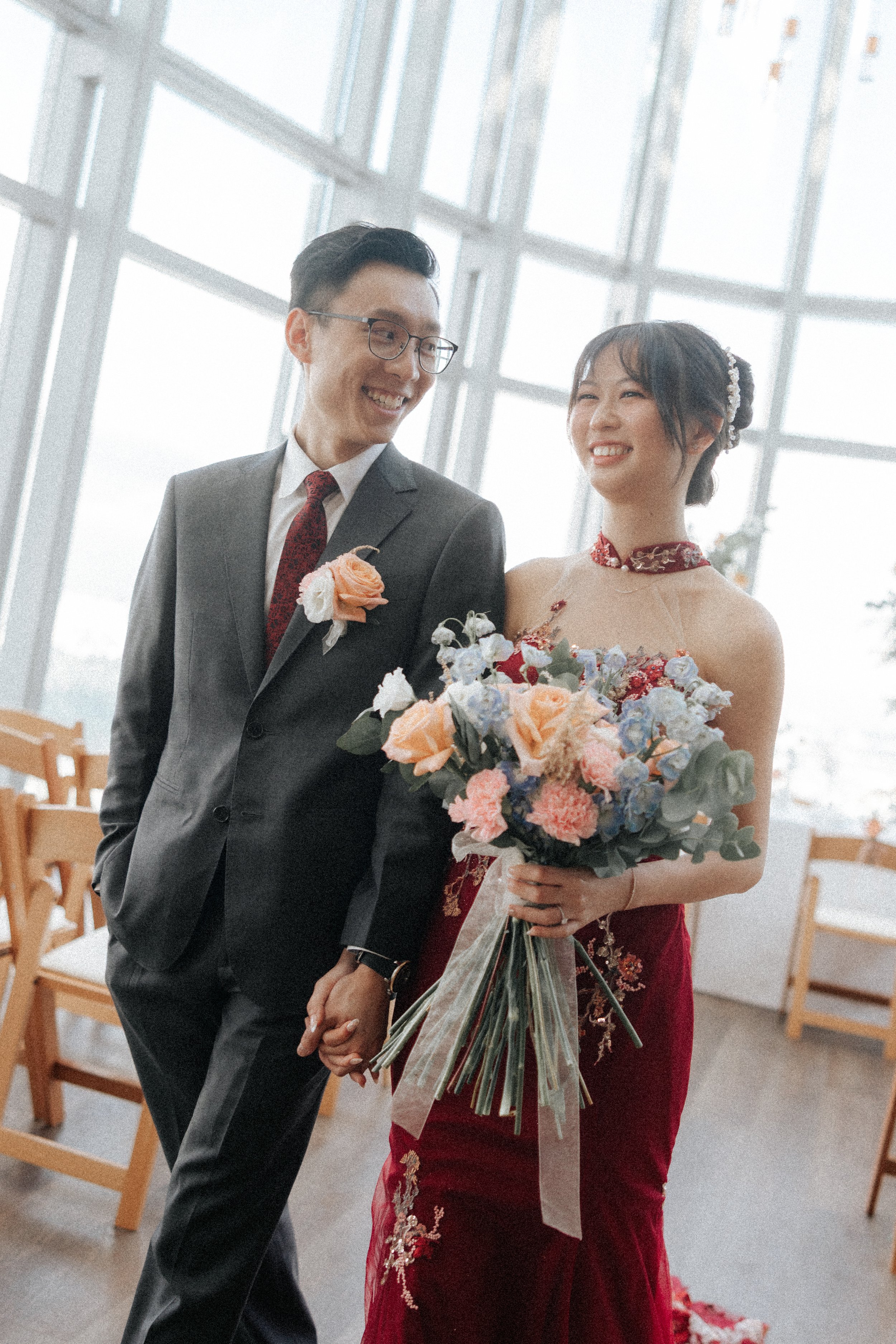 Romantic photograph of a couple of their actual day wedding as they walk down their wedding venue together in a light and airy style. Photographed by Breadandbutterworks.
