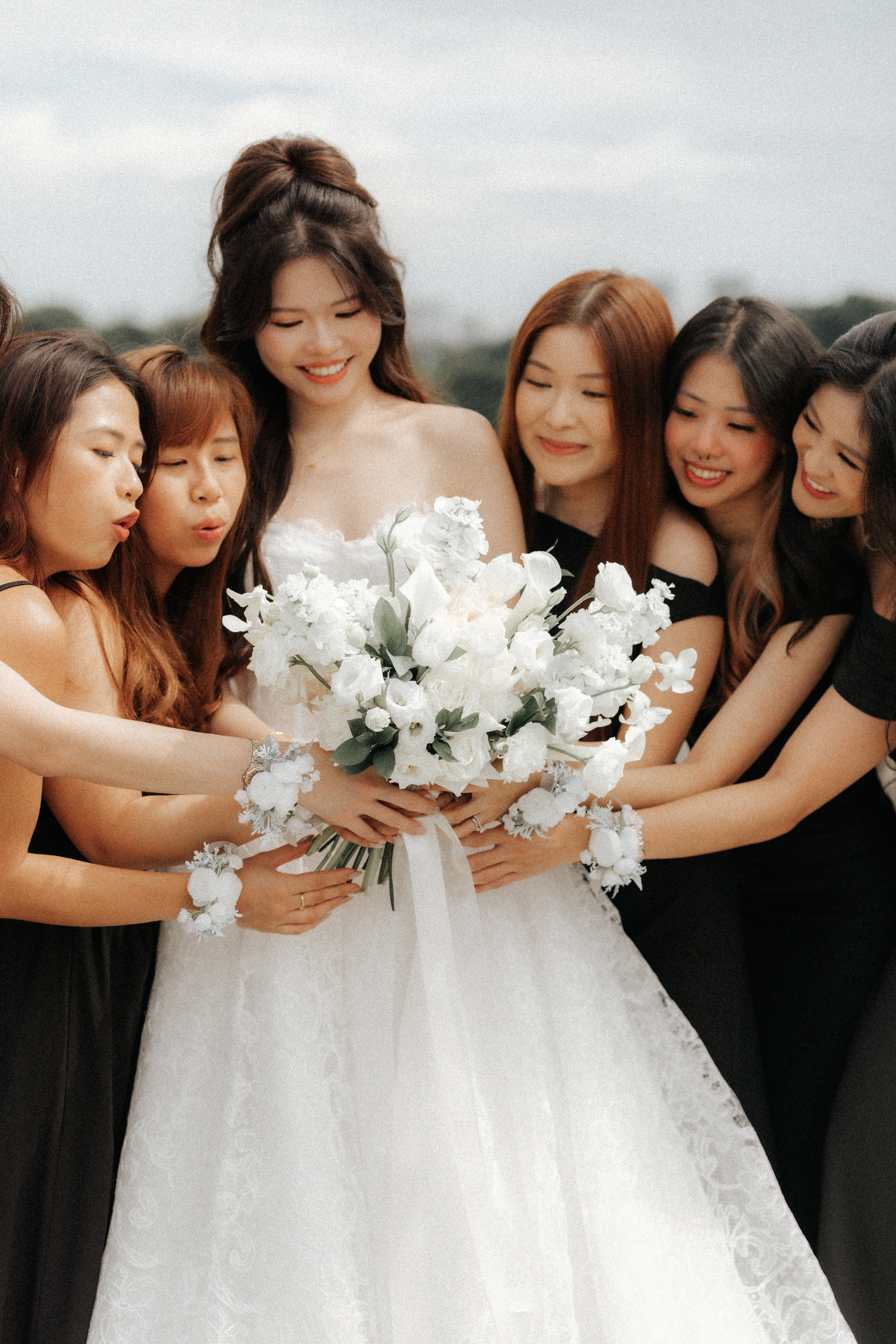 Charming actual day wedding photo of the bride and her bridesmaids, this was captured along Marina Barrage by Breadandbutterworks in a soft and heartfelt style.