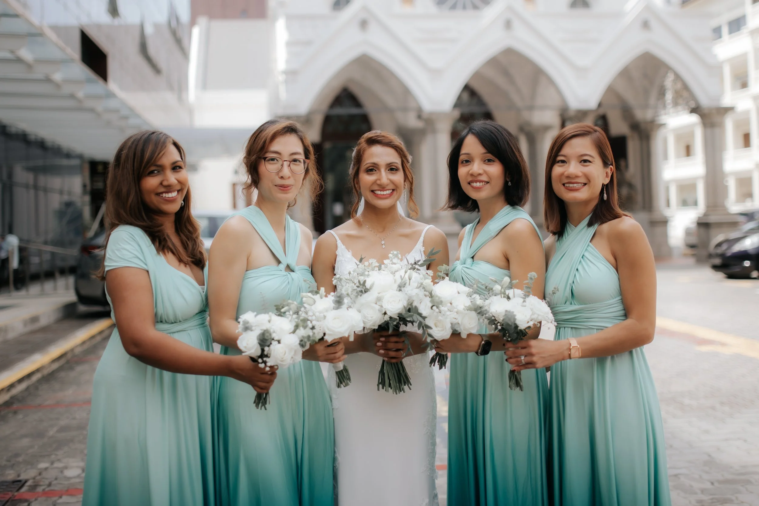 Light and airy actual day church wedding photoshoot at Church of Saints Peter and Paul, this photo of the bride and her bridesmaids was captured by Ash for Breadandbutterworks.