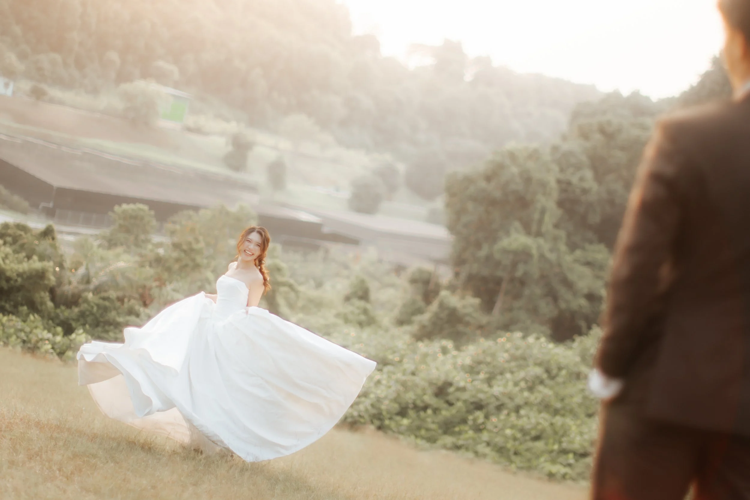 Romantic and dynamic pre-wedding photoshoot at Canterbury Hill. The bride is running towards the groom as her gown flows gracefully around her. Captured in a light and airy style by Arielle from Breadandbutterworks.