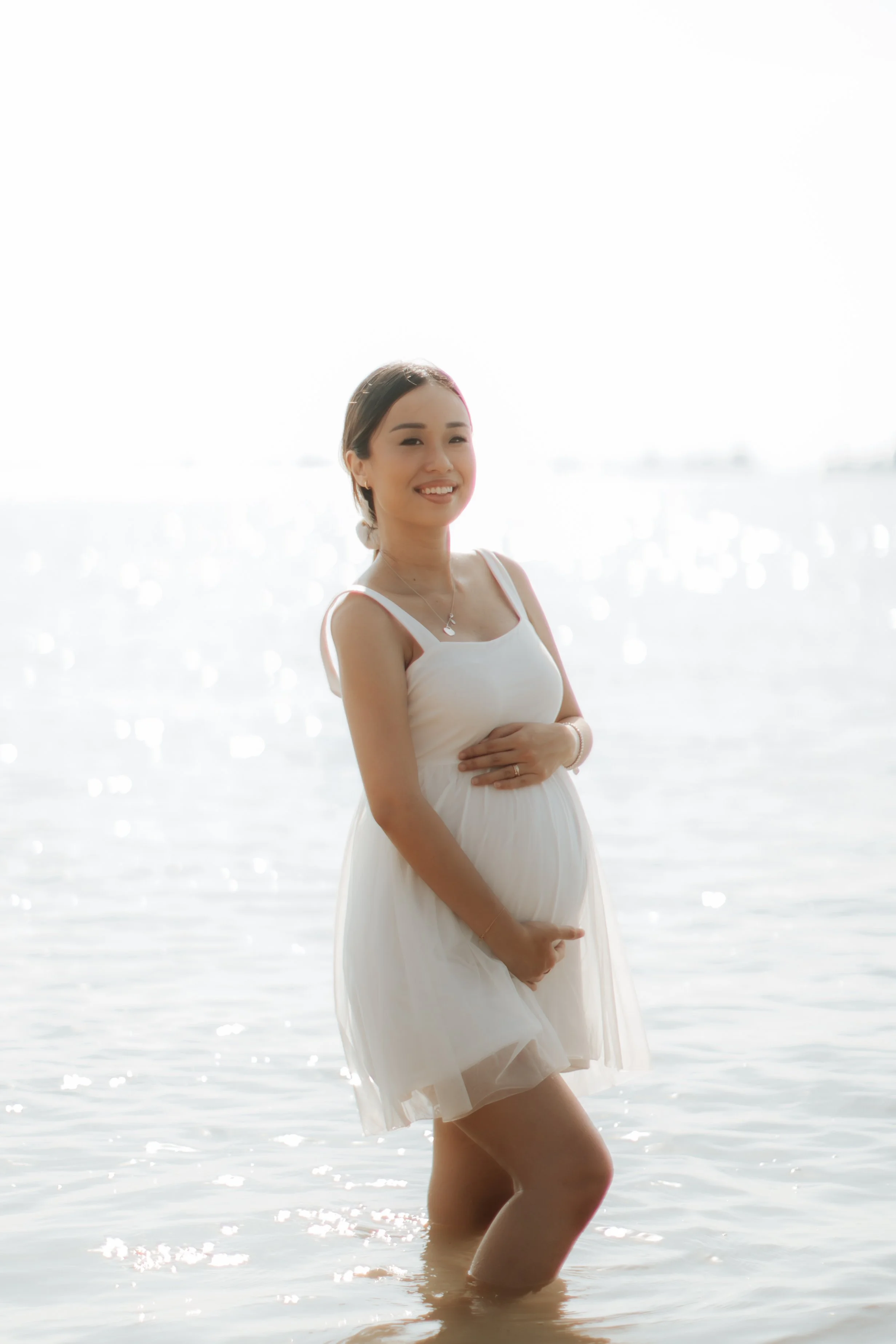 Light and airy maternity beach photoshoot at East Coast Park with a pet dog, captured by Arielle for Breadandbutterworks.