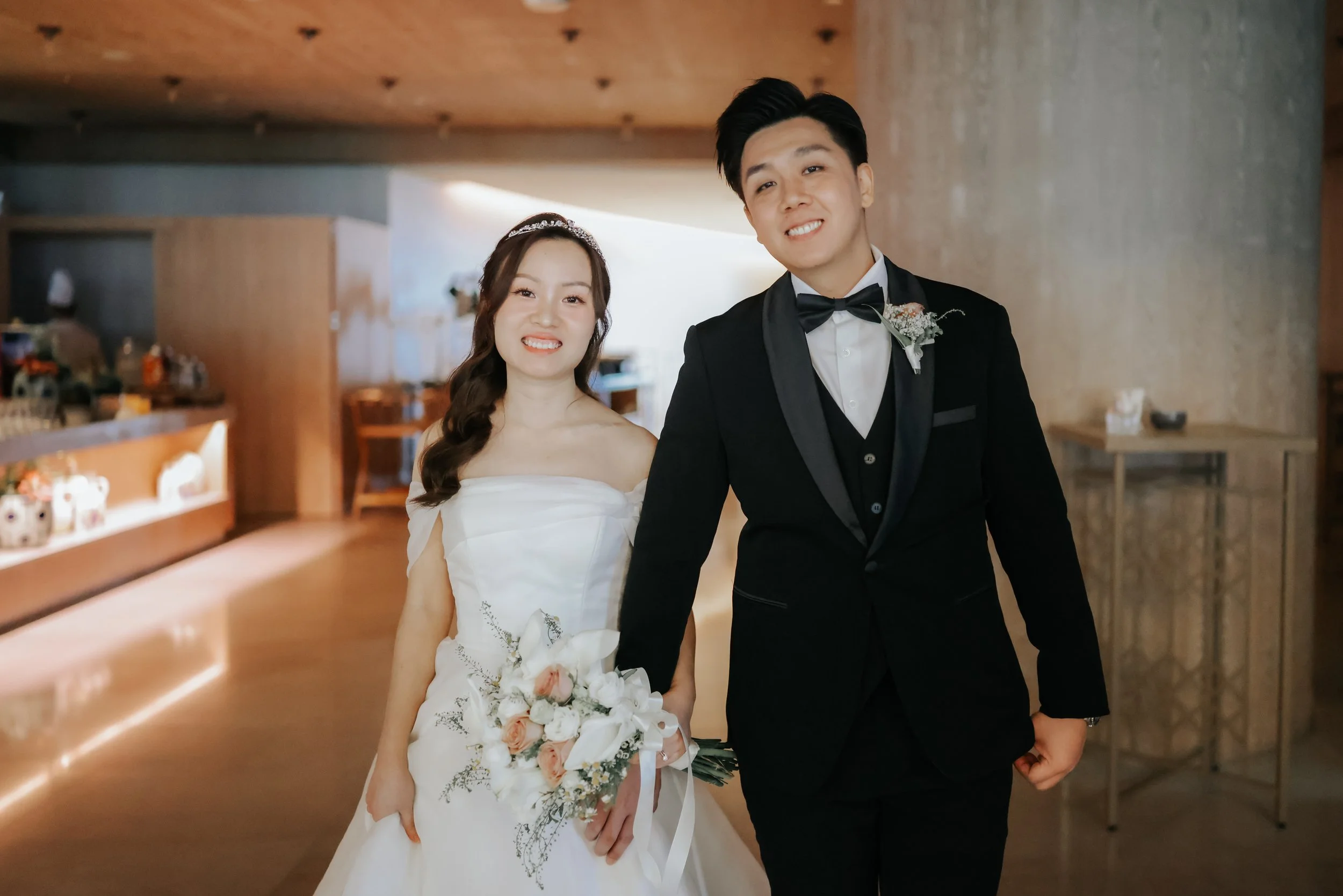 Joyful actual day wedding photoshoot of a couple posing for the camera as they are heading towards their wedding, captured by Breadandbutterworks in a soft and heartfelt style.