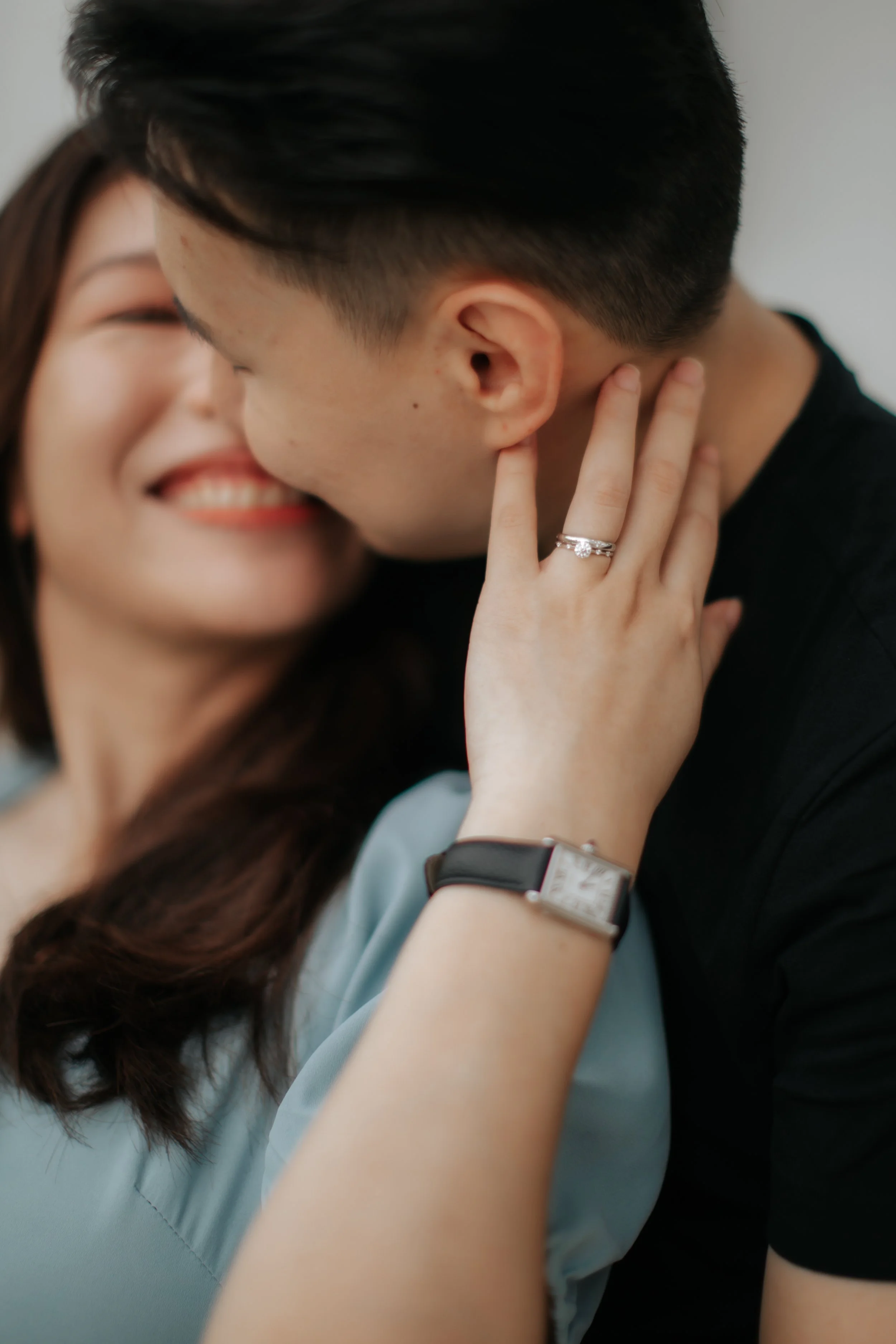 A close-up shot of a couple during their maternity shoot as they embrace and look into each other intimately, captured by Breadandbutterworks in a soft and heartfelt style.