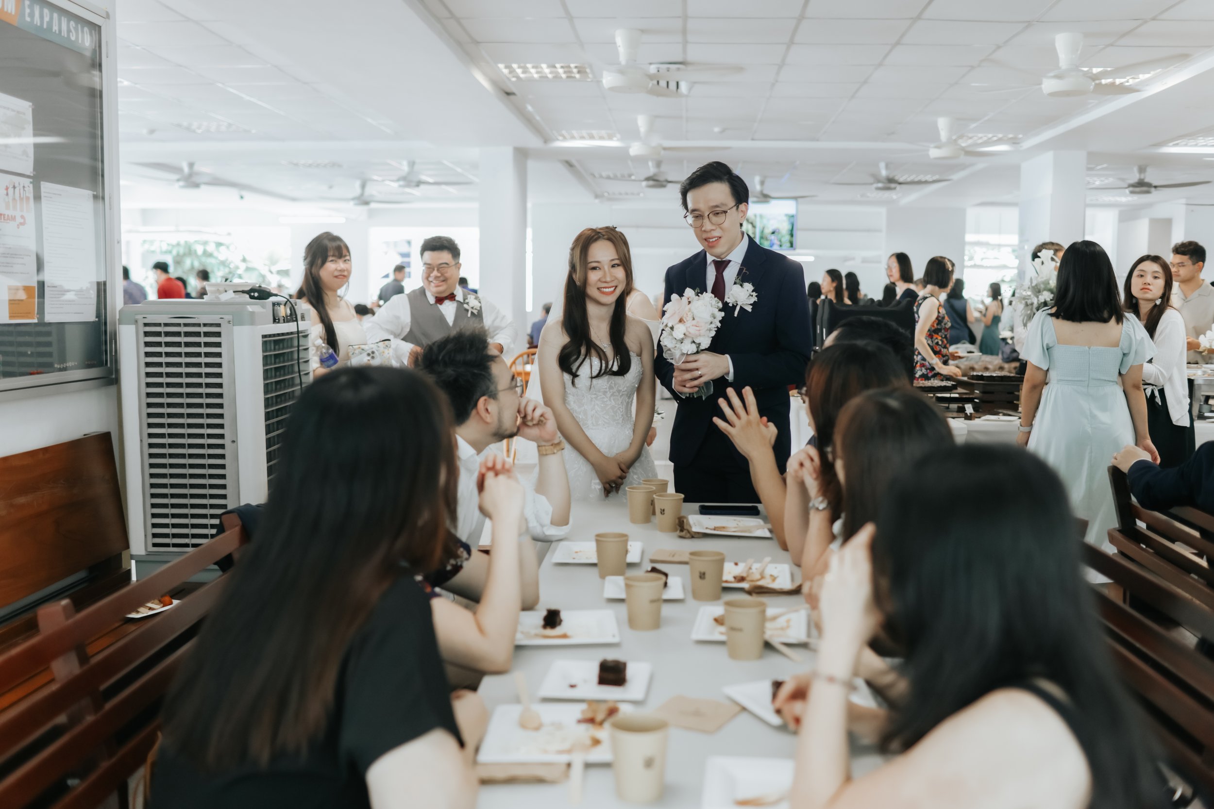 Light and airy actual day photoshoot of a couple at Bukit Panjang Church, the couple are chatting with their guests at their table. Captured by Arielle for Breadandbutterworks.