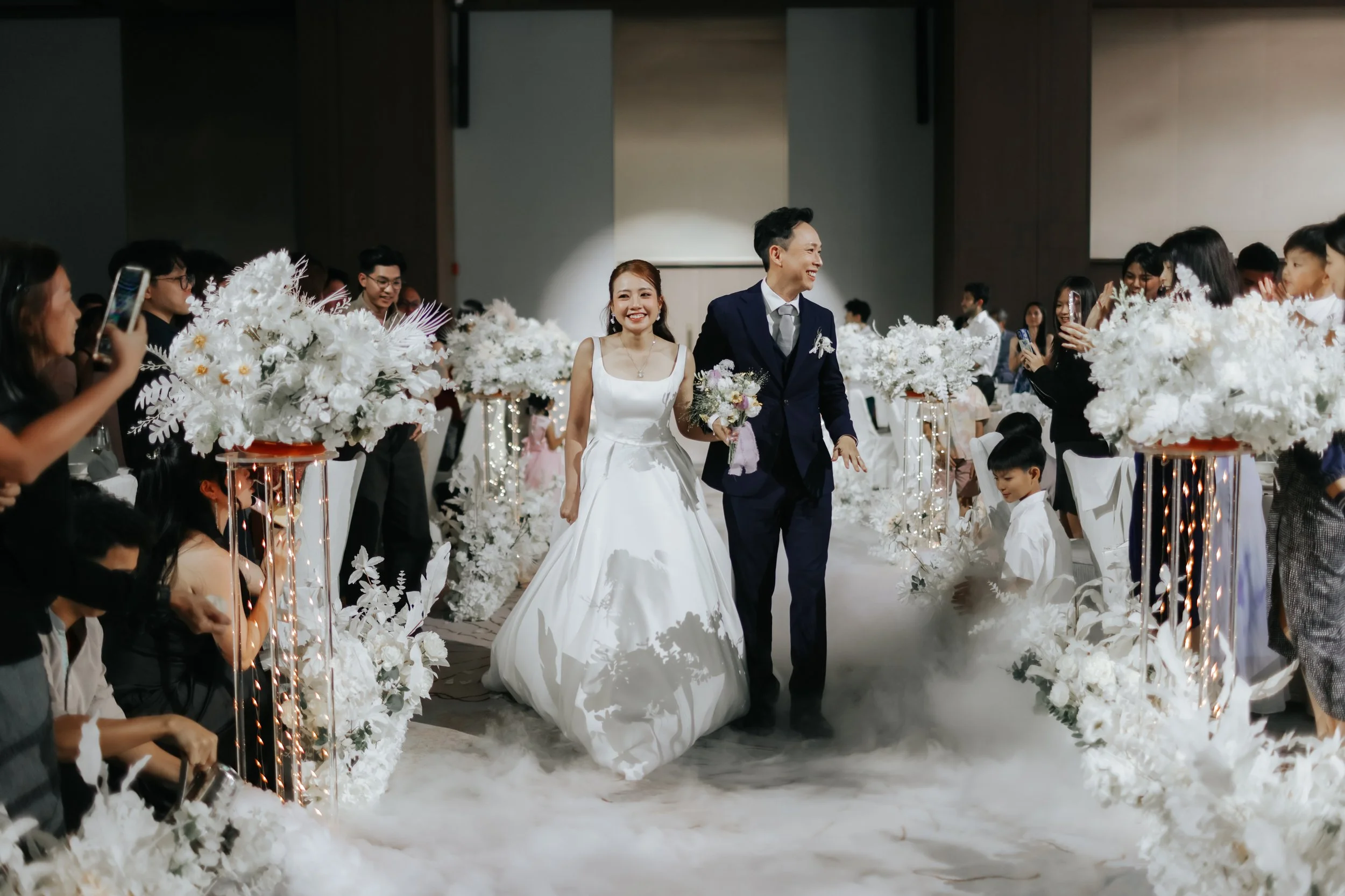 Cover image for Arielle’s actual day wedding photography collection, featuring a couple walking down the aisle during their wedding march-in in Singapore.
