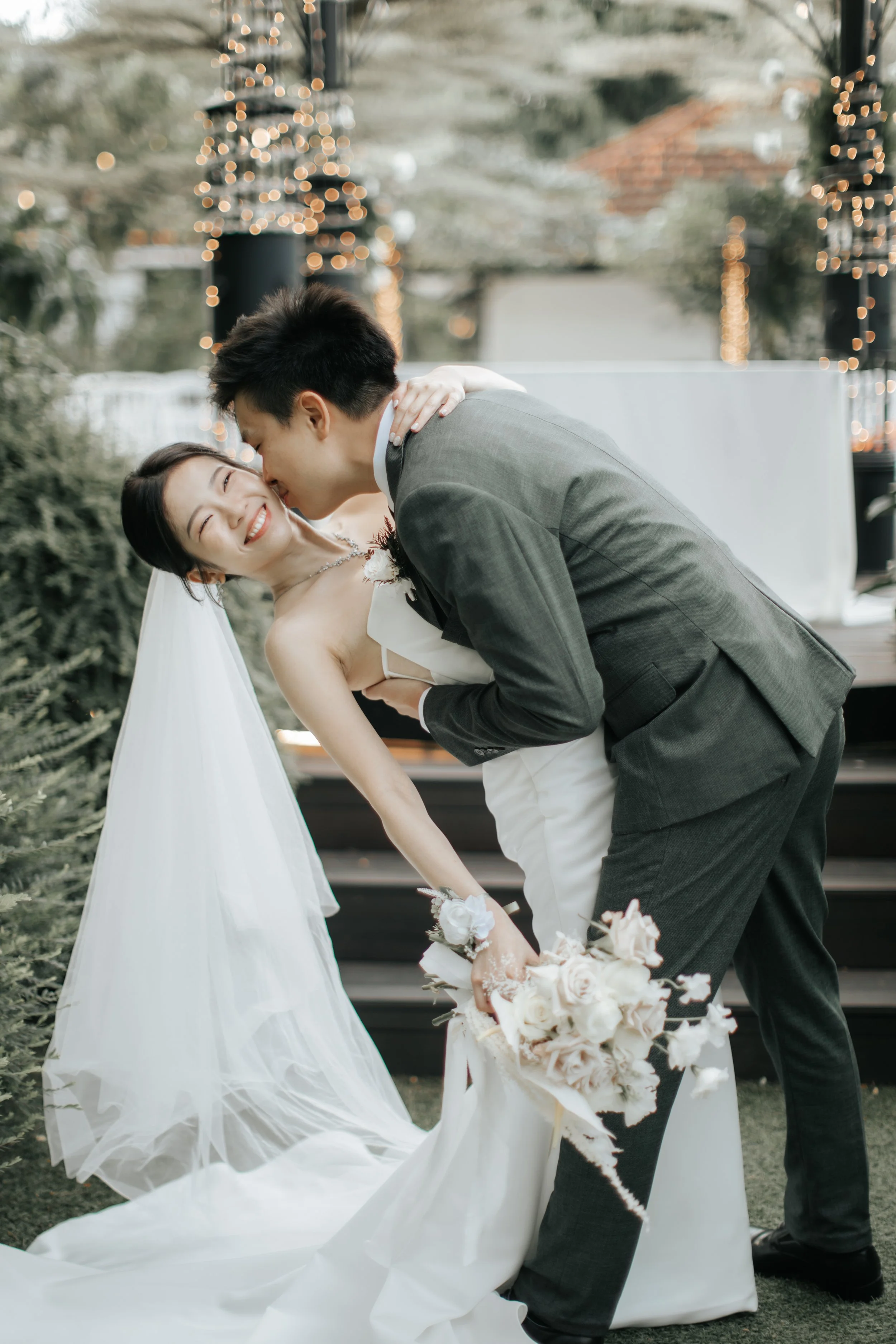 Light and airy actual day wedding photoshoot at the Summerhouse in Singapore of the couple sharing a romantic kiss. Captured by Arielle for Breadandbutterworks.