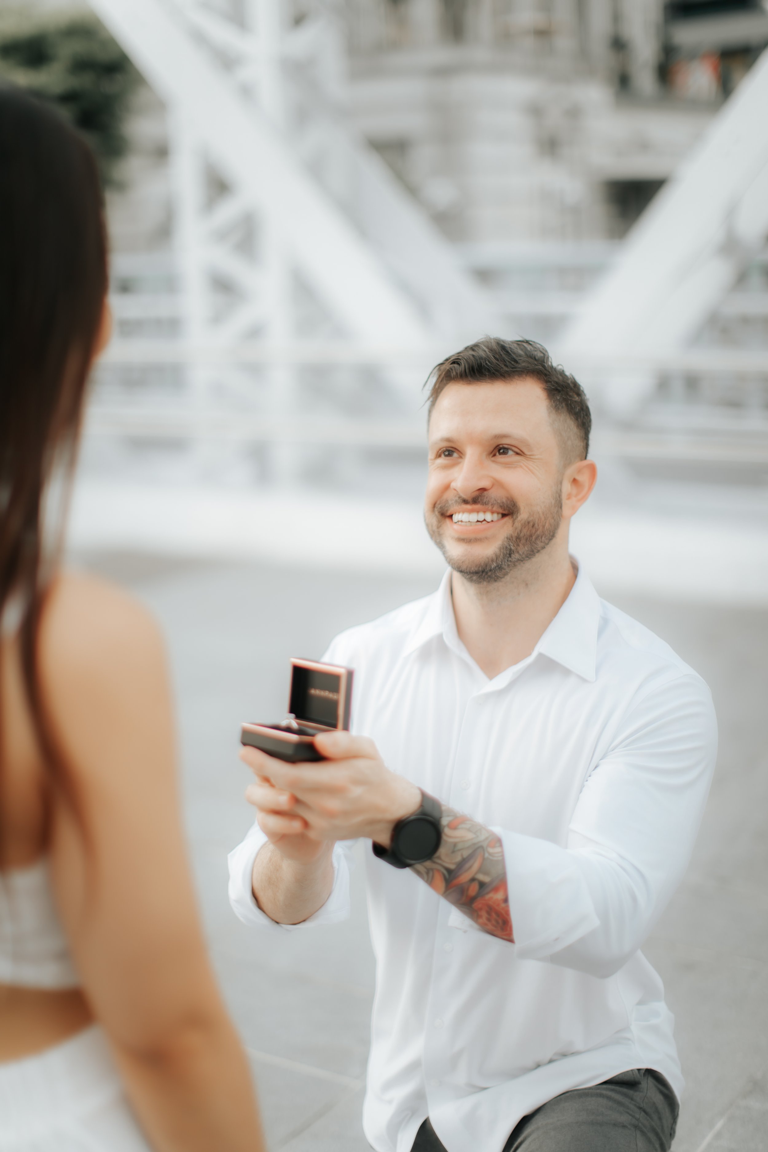 Light and airy proposal photoshoot at Anderson Bridge, the groom-to-be gets on one knee and pops the question. Captured by Arielle for Breadandbutterworks.