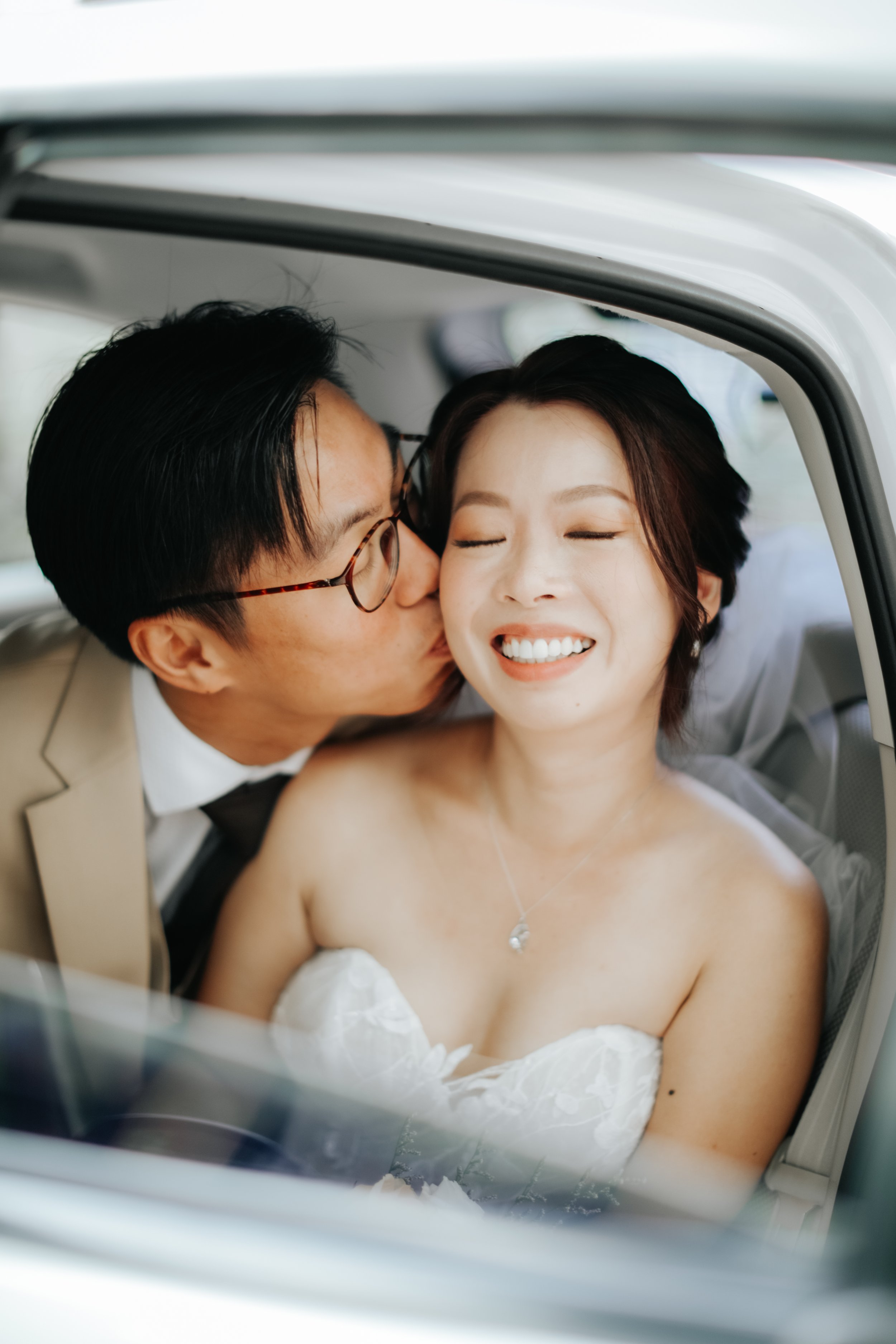 Light and airy actual day wedding photoshoot of a couple in their matrimonial car, captured by Arielle for Breadandbutterworks.