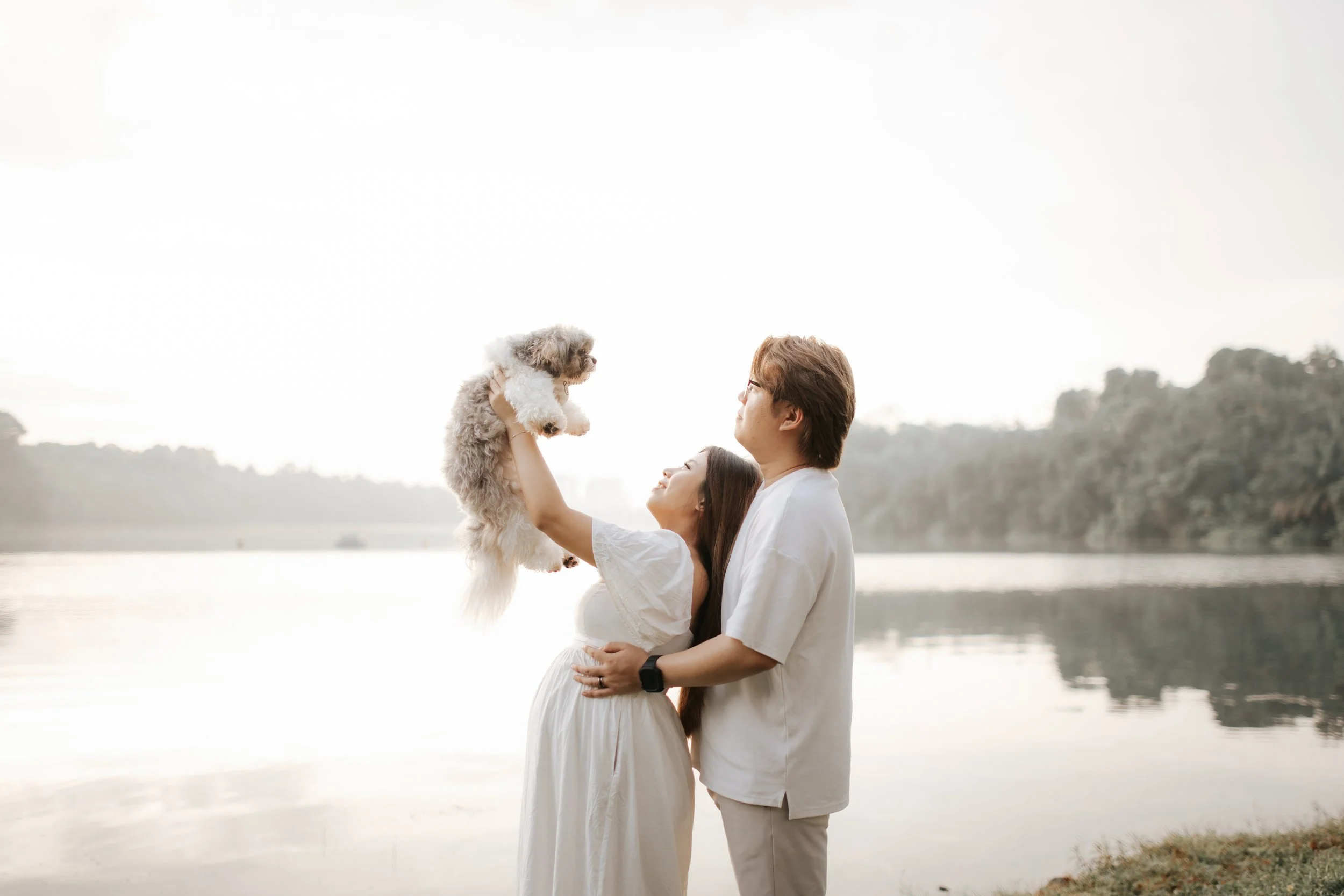 Warm and candid maternity photoshoot with their family dog, taken during golden hour at Upper Peirce Reservoir. Captured by Breadandbutterworks in a light and airy style.