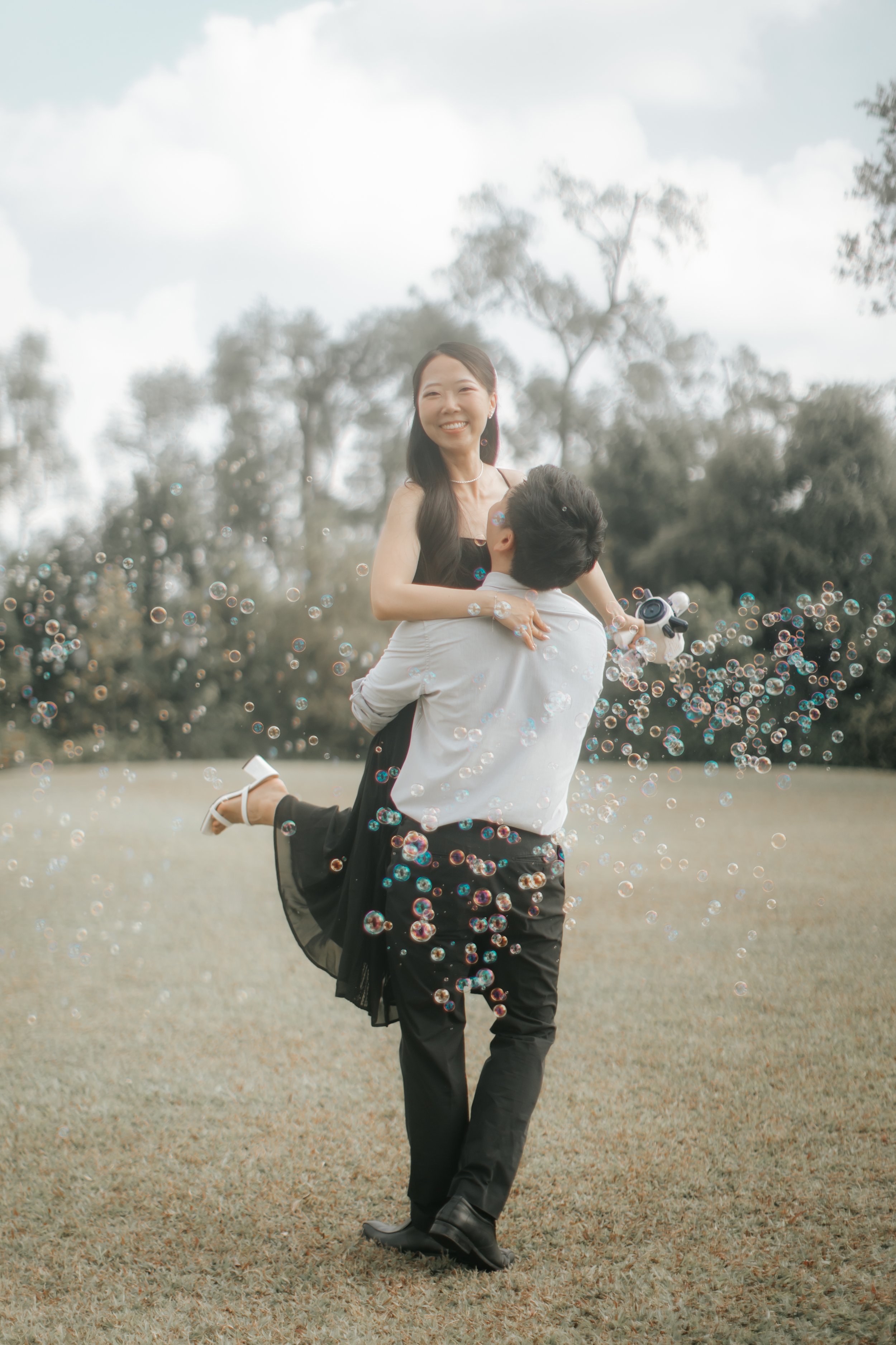 Light and airy pre-wedding photoshoot of a couple at Bandstand and Gallop Extension in Singapore surrounded with bubbles. Captured by Arielle from Breadandbutterworks.
