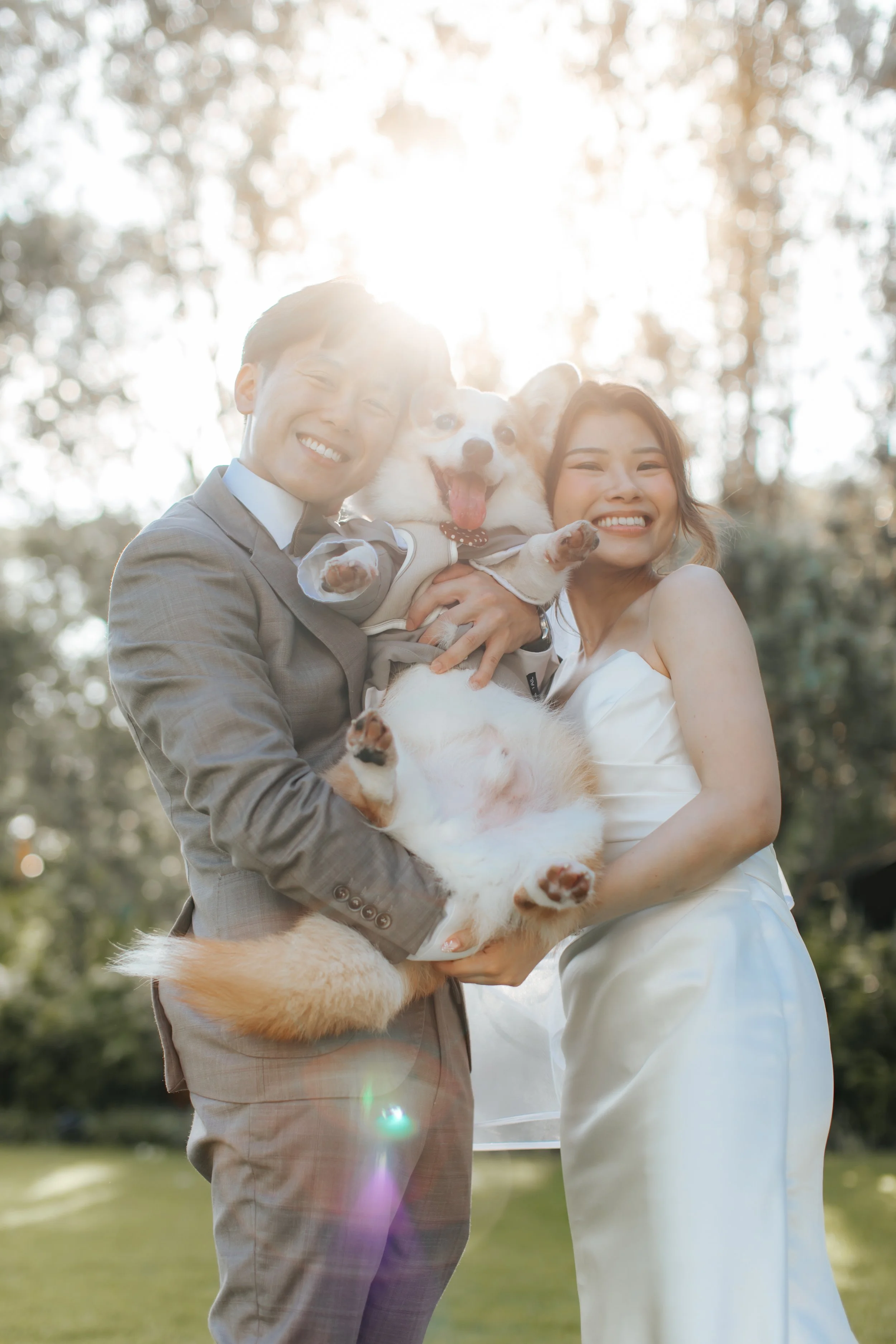 Light and airy actual day wedding photoshoot at Canopy HortPark, the couple poses in a park with their pet dog. Captured by Arielle from Breadandbutterworks.