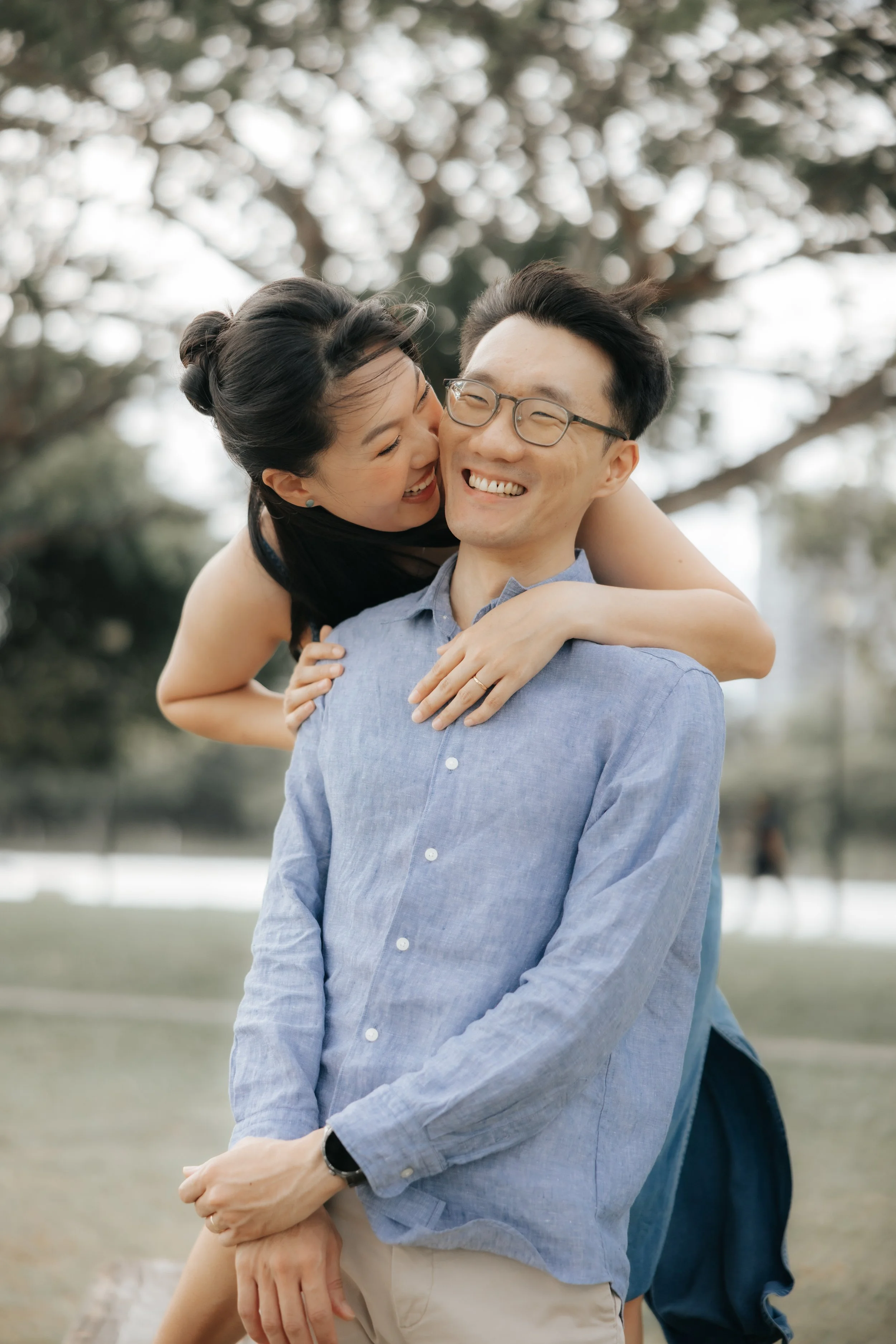 Playful pre-wedding photo of a couple sharing a moment at East Coast Park, captured by Breadandbutterworks in a soft and heartfelt style.
