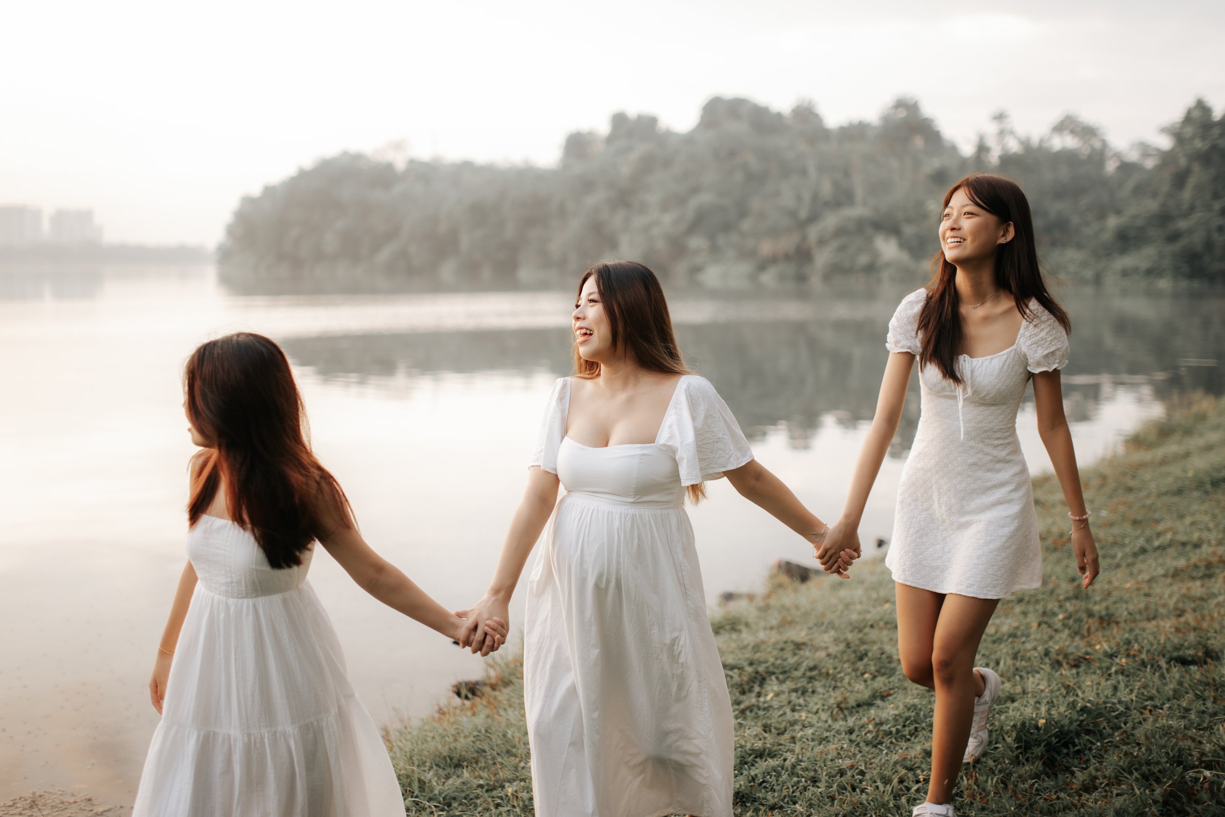 Warm and candid family photoshoot of the three sisters, taken at Upper Peirce Reservoir. Captured by Breadandbutterworks in a light and airy style.