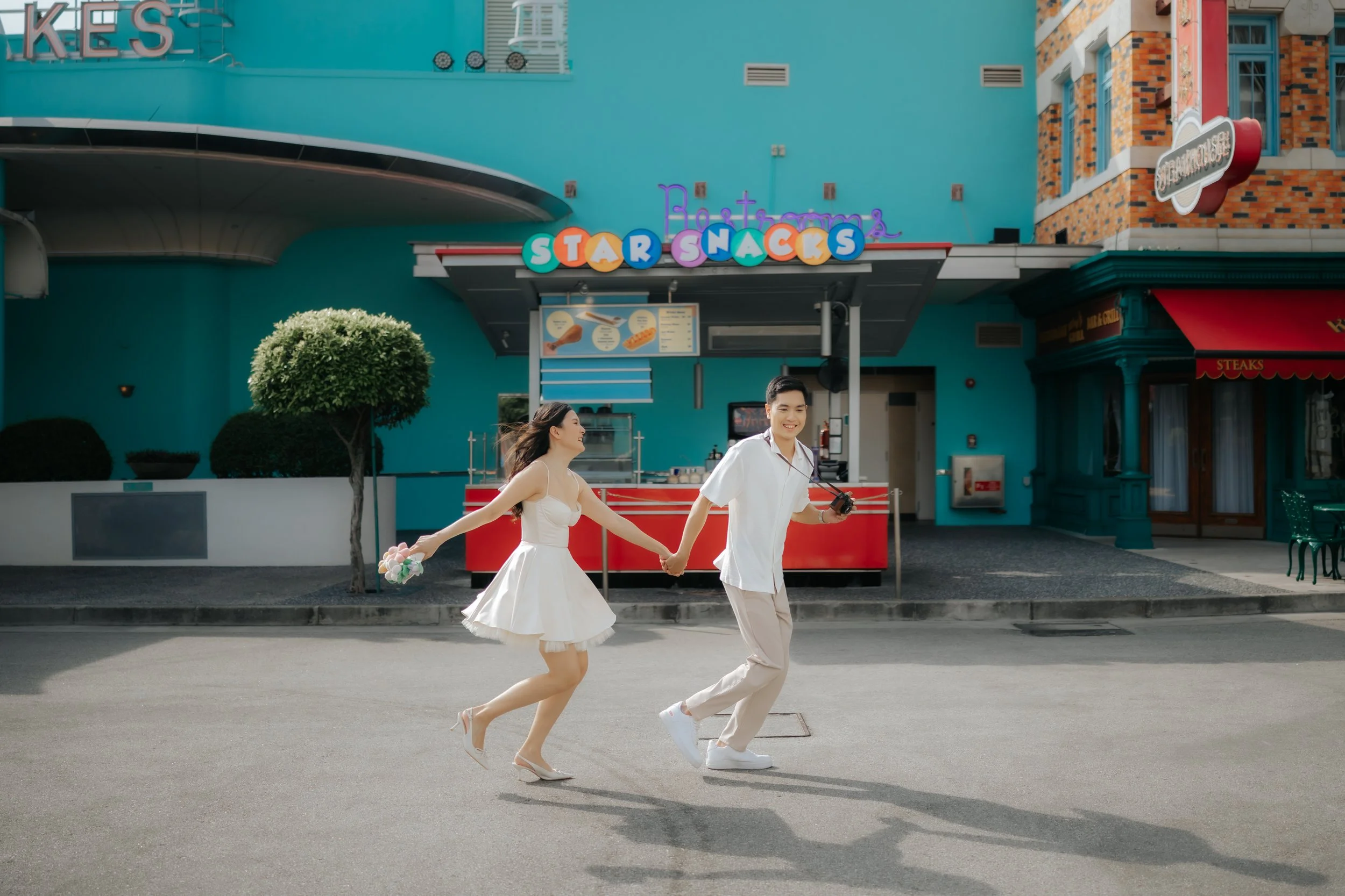 Couple posing for pre-wedding photoshoot in Universal Studios Singapore, captured by Ash for Breadandbutterworks.