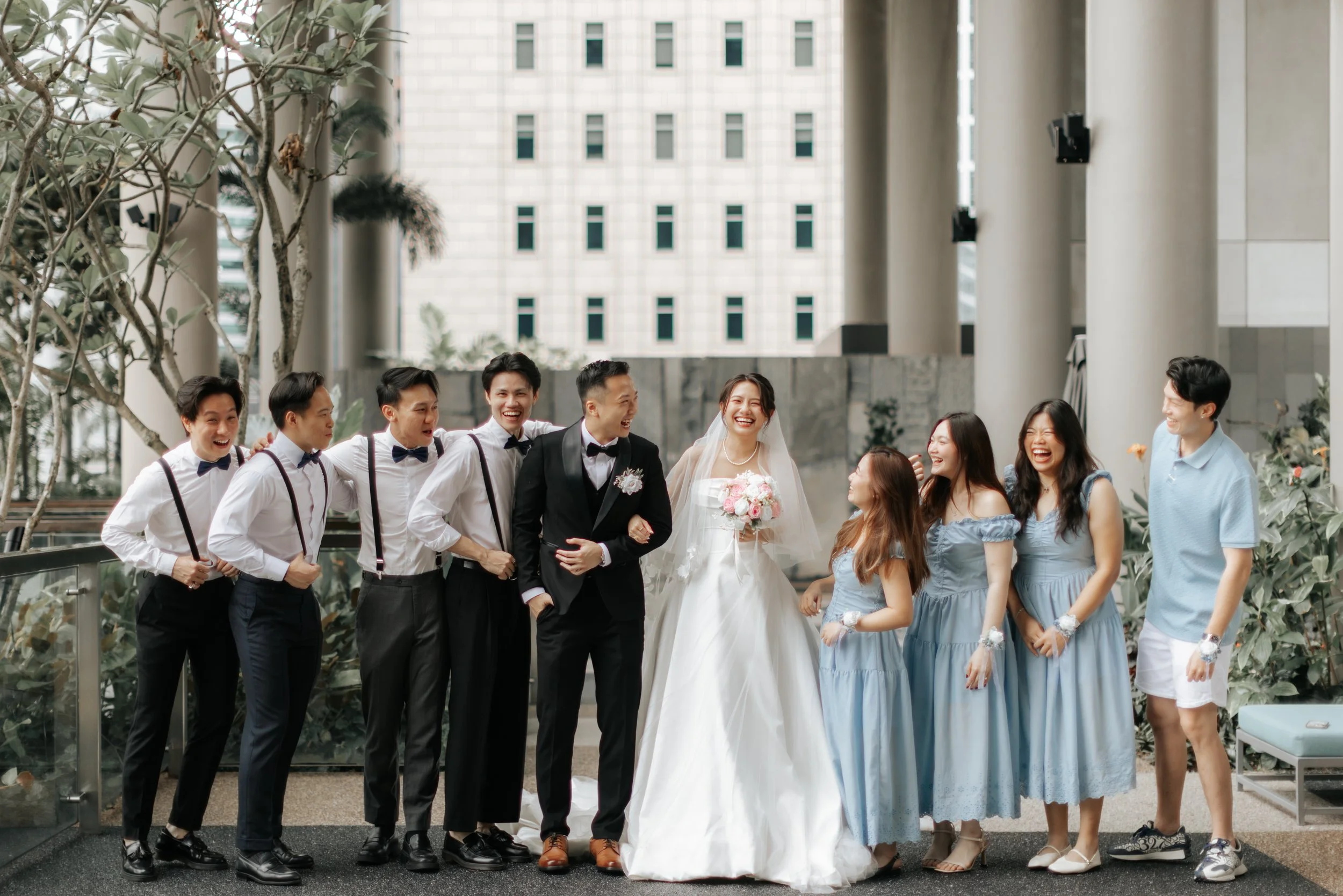 Joyful actual day wedding photography of the couple and bridal party, featuring the groomsmen and bridesmaids, captured by Breadandbutterworks in a soft and heartfelt style.