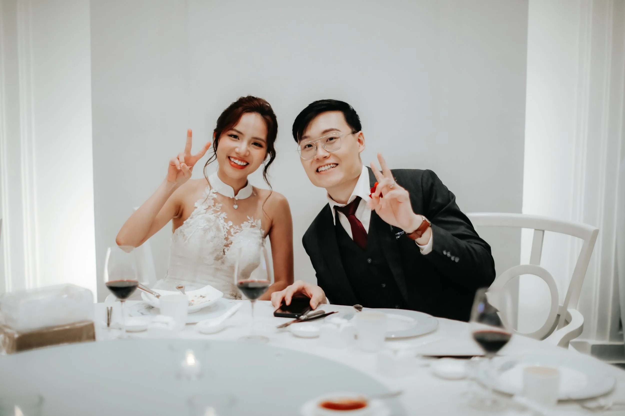 Light and airy actual day wedding photography of the bride and groom posing in their wedding venue at Fullerton Hotel. Captured by Arielle for Breadandbutterworks.