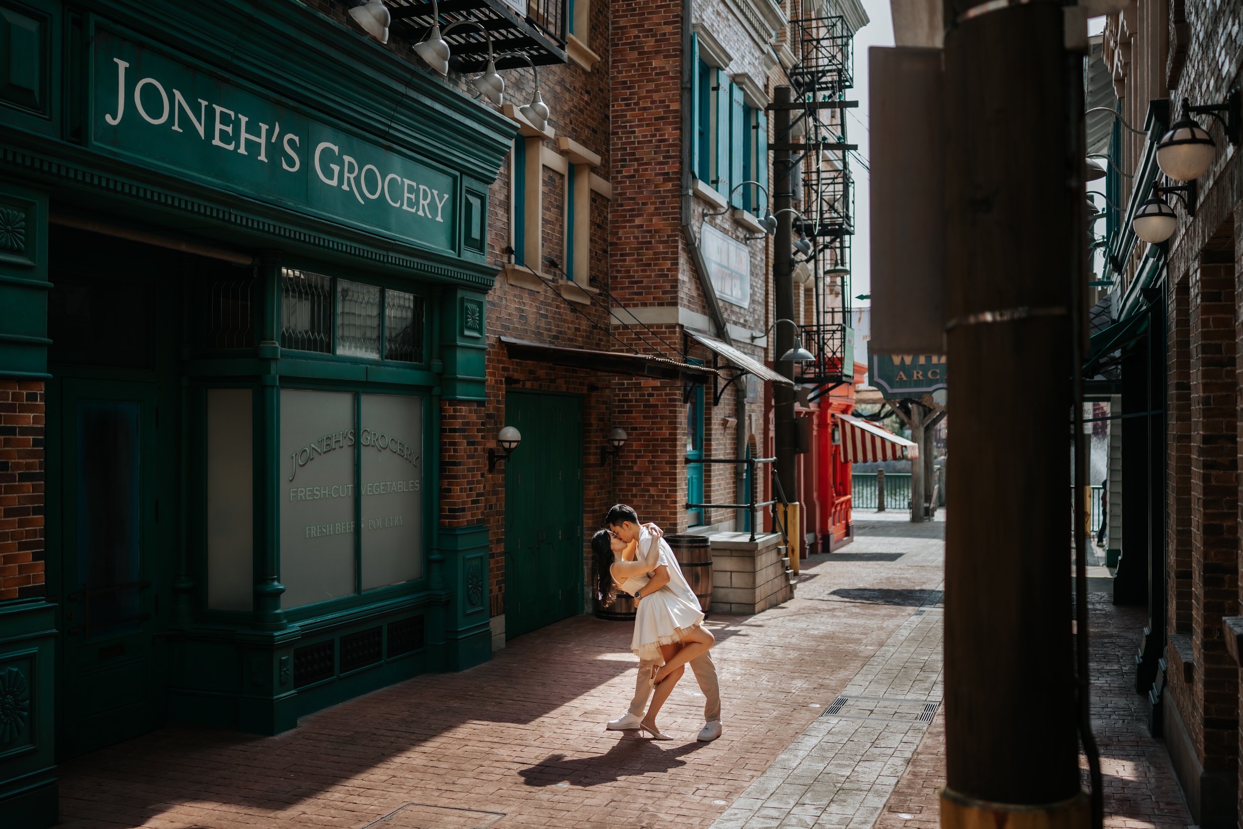 Cinematic photo of couple posing for pre-wedding photoshoot in Universal Studios Singapore, captured by Ash for Breadandbutterworks.