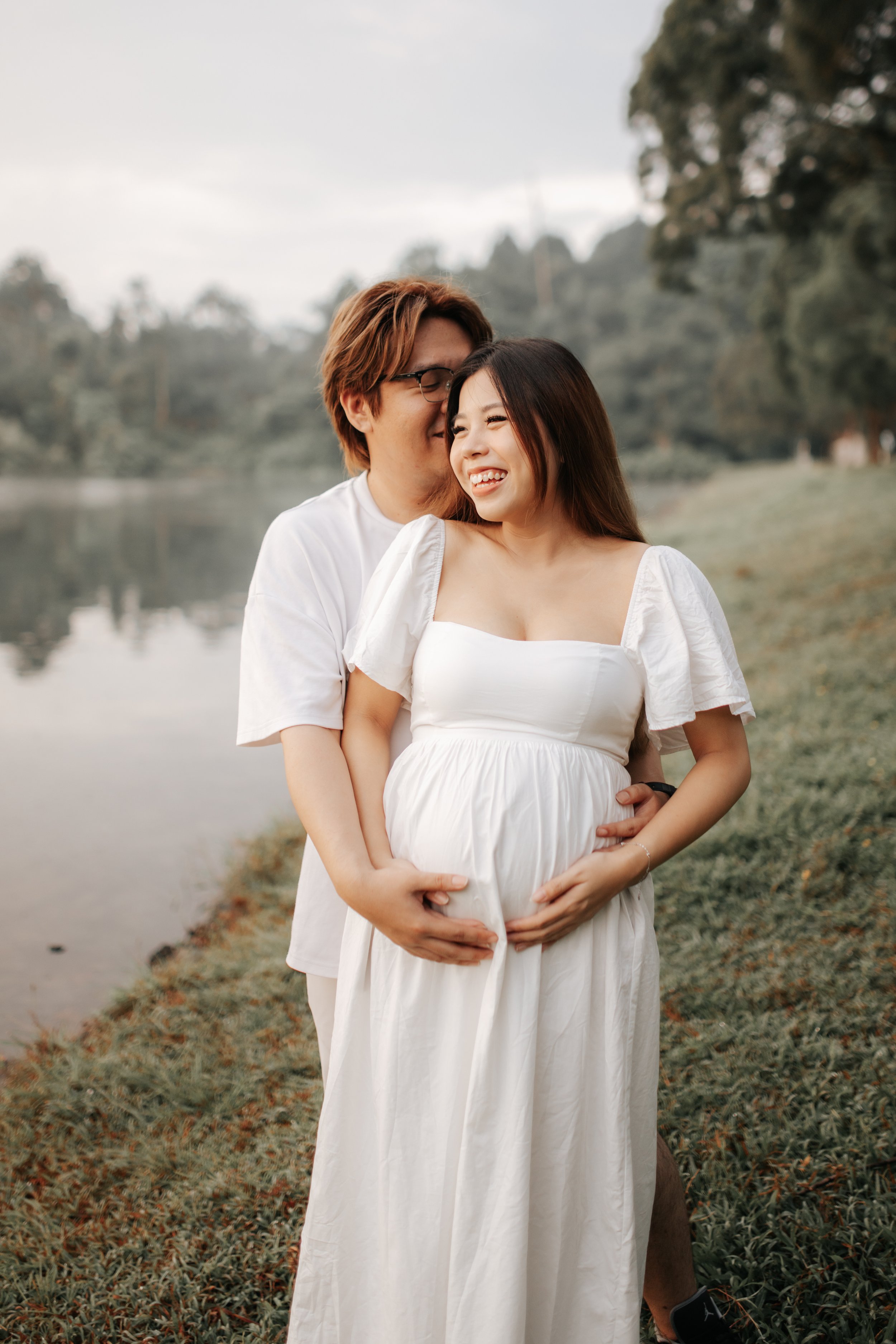 Warm and candid maternity photoshoot, taken during golden hour at Upper Peirce Reservoir. Captured by Breadandbutterworks in a light and airy style.