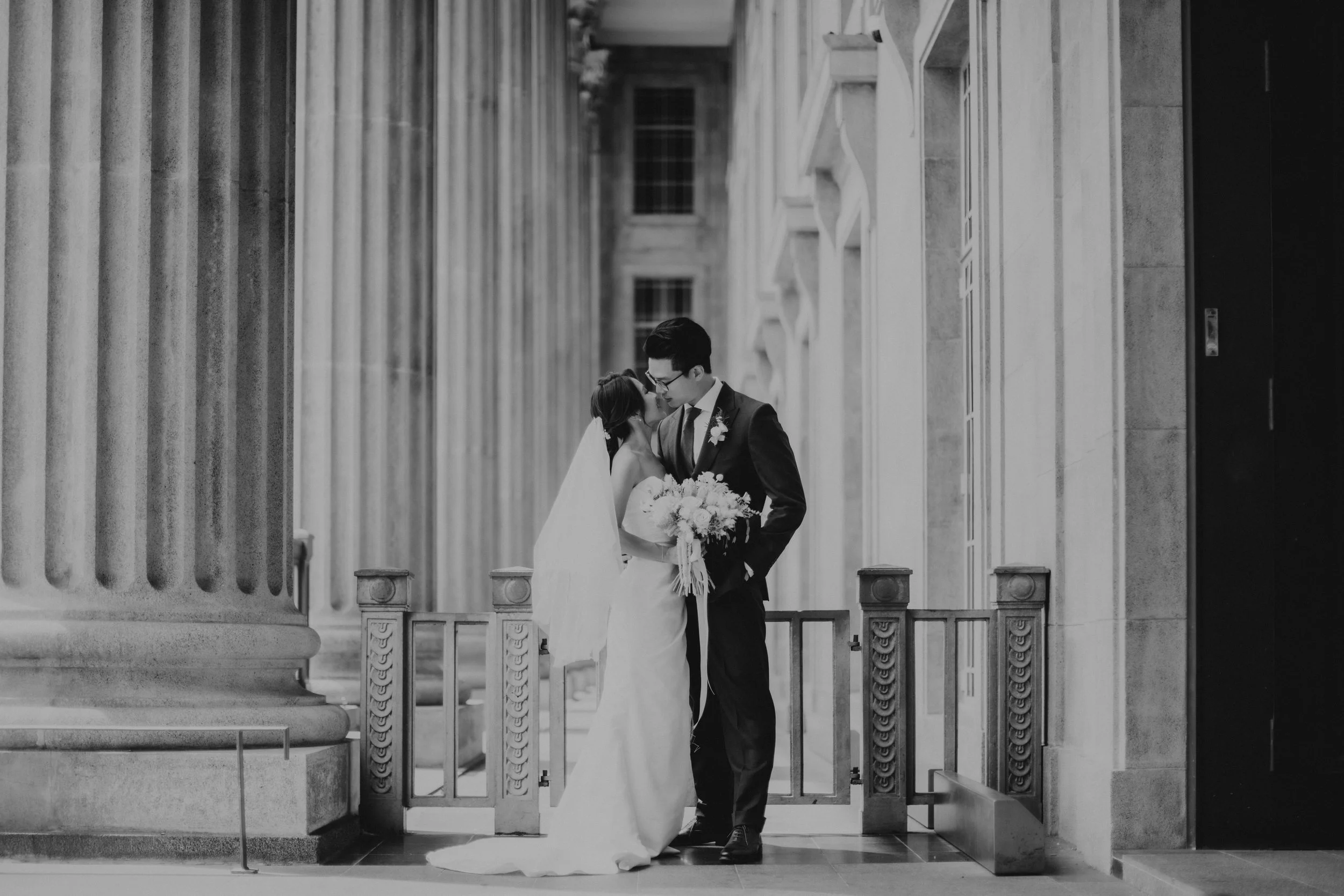 Cinematic black and white actual day wedding photography at Sky Garden Sentosa in Singapore, the couple at the stairway is captured by Ash for Breadandbutterworks.