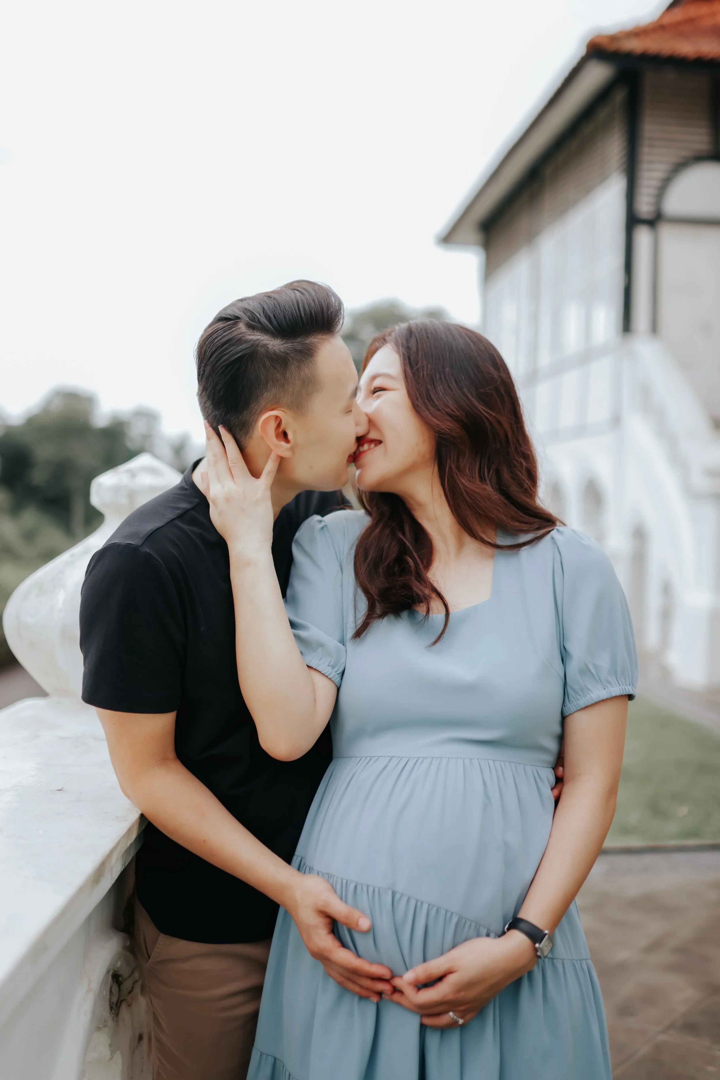 A couple poses for their maternity shoot with Gallop Extention in Singapore as their background, captured by Breadandbutterworks in a soft and heartfelt style.