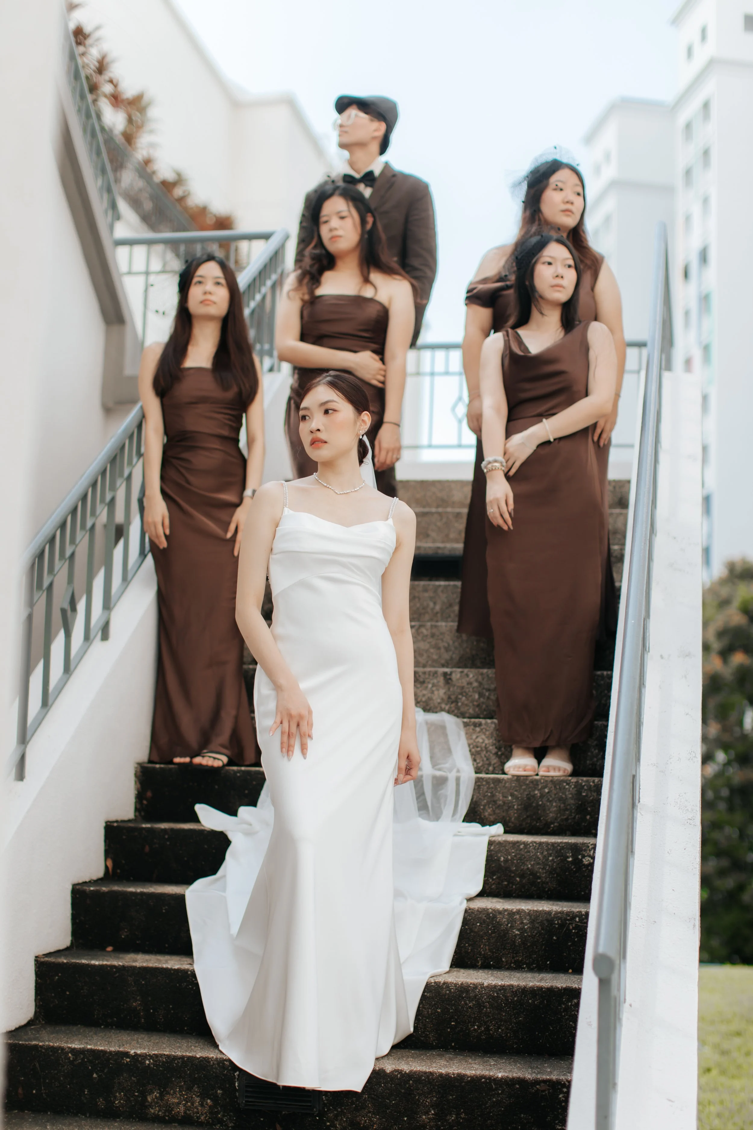 Light and airy actual day wedding photoshoot of the bride and her bridesmaid. They are walking down a flight of stairs looking very cinematic and cool. Captured by Arielle from Breadandbutterworks.