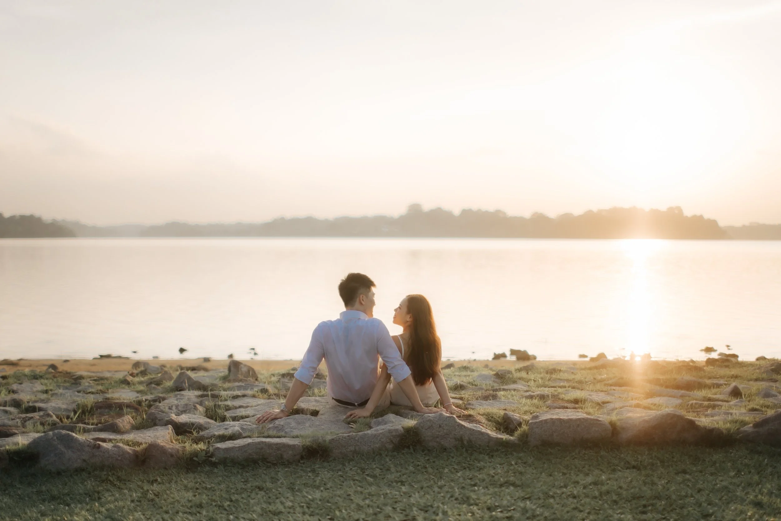 Romantic and airy pre-wedding photoshoot at Upper Seletar Reservoir, the couple is having a conversion in this intimate shot. Captured by Arielle from Breadandbutterworks.