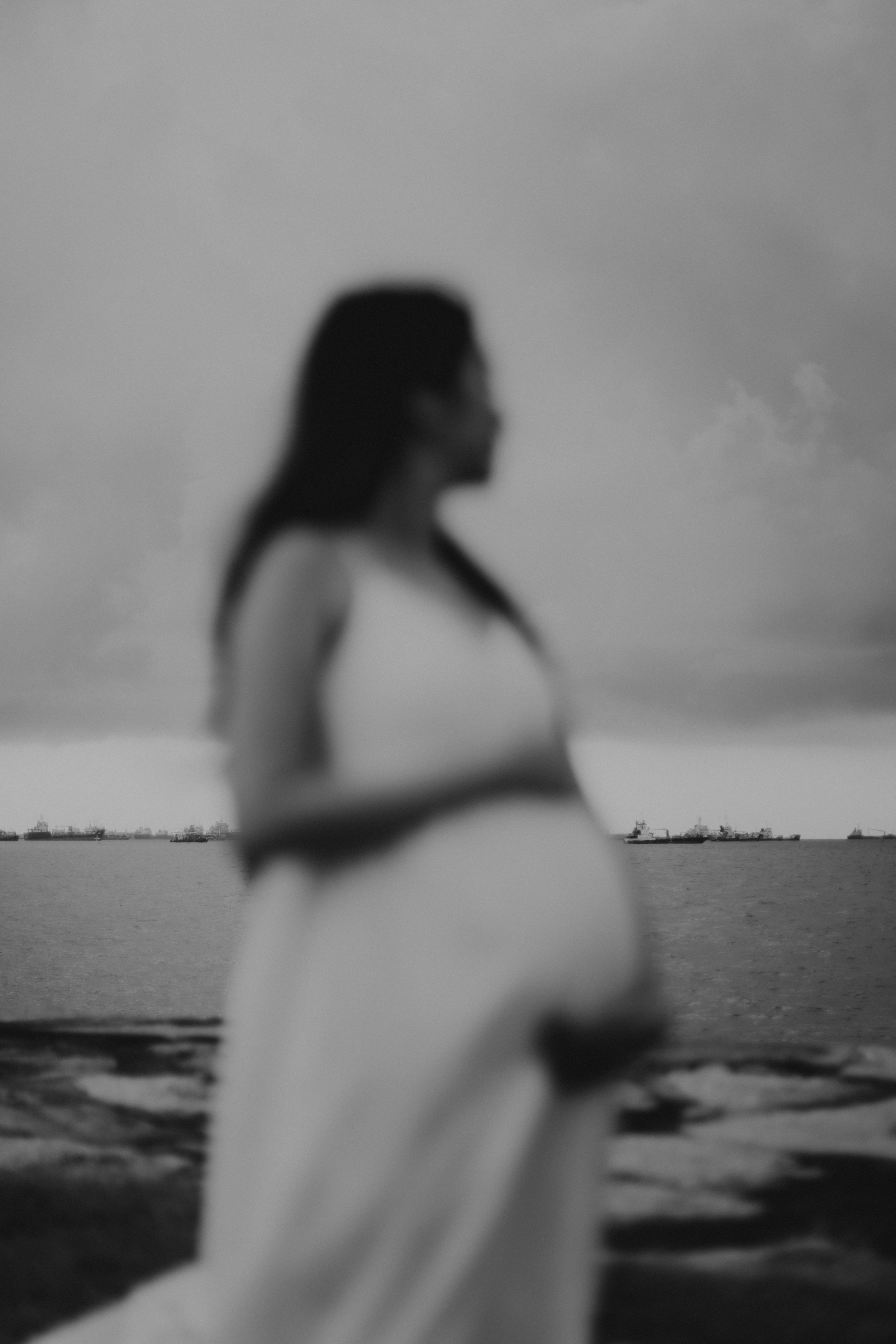 Cinematic black and white maternity shoot at sunset at East Coast Park in Singapore, captured by Arielle for Breadandbutterworks.