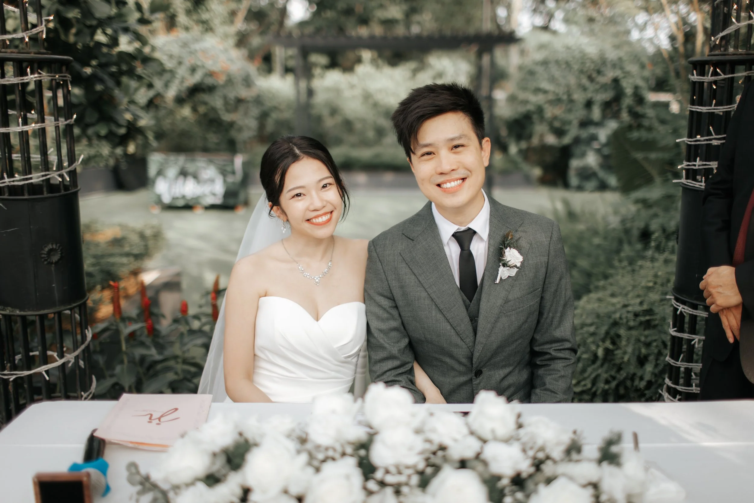 Light and airy actual day wedding photoshoot at the Summerhouse in Singapore of the couple posing for a photo right after they signed their wedding certificate. Captured by Arielle for Breadandbutterworks.