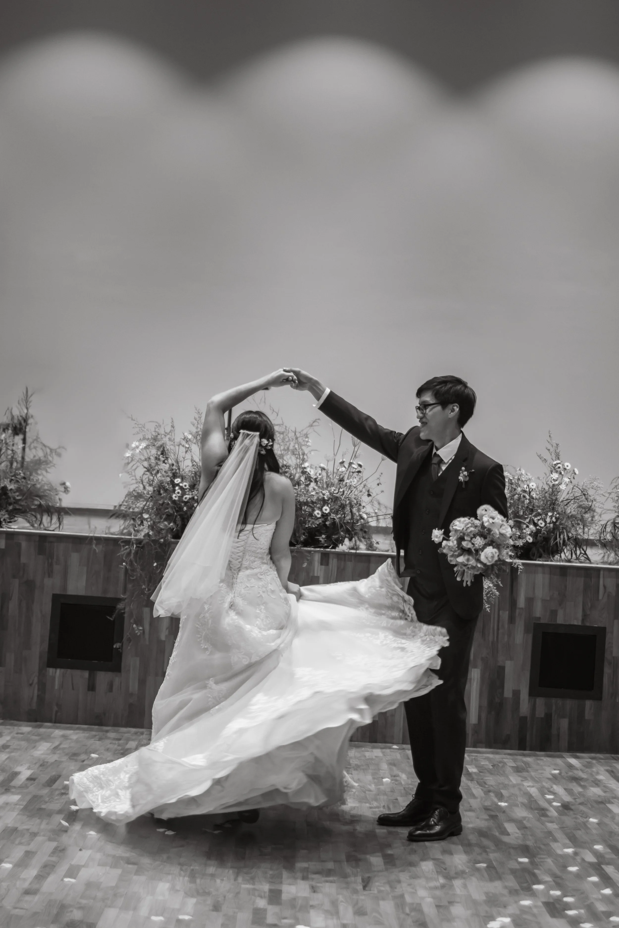 Cinematic black and white actual day wedding shoot of the bride and groom dancing at Adam Road Presbyterian Church in Singapore. Captured by Arielle for Breadandbutterworks.