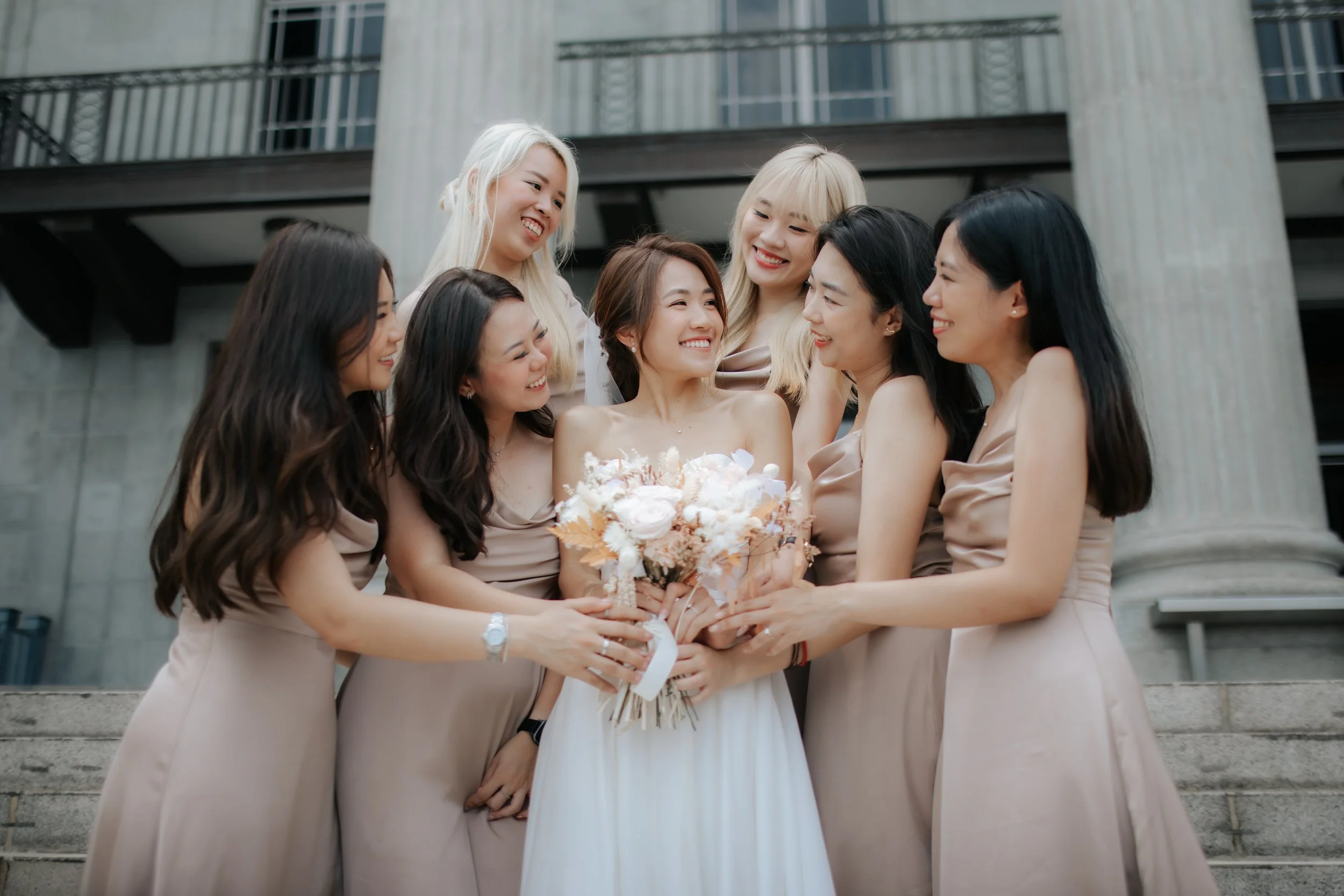 Actual day wedding photography of a bride and her bridesmaids outside the wedding venue which is Sky Garden at Sentosa Singapore. Captured by Ash for Breadandbutterworks.