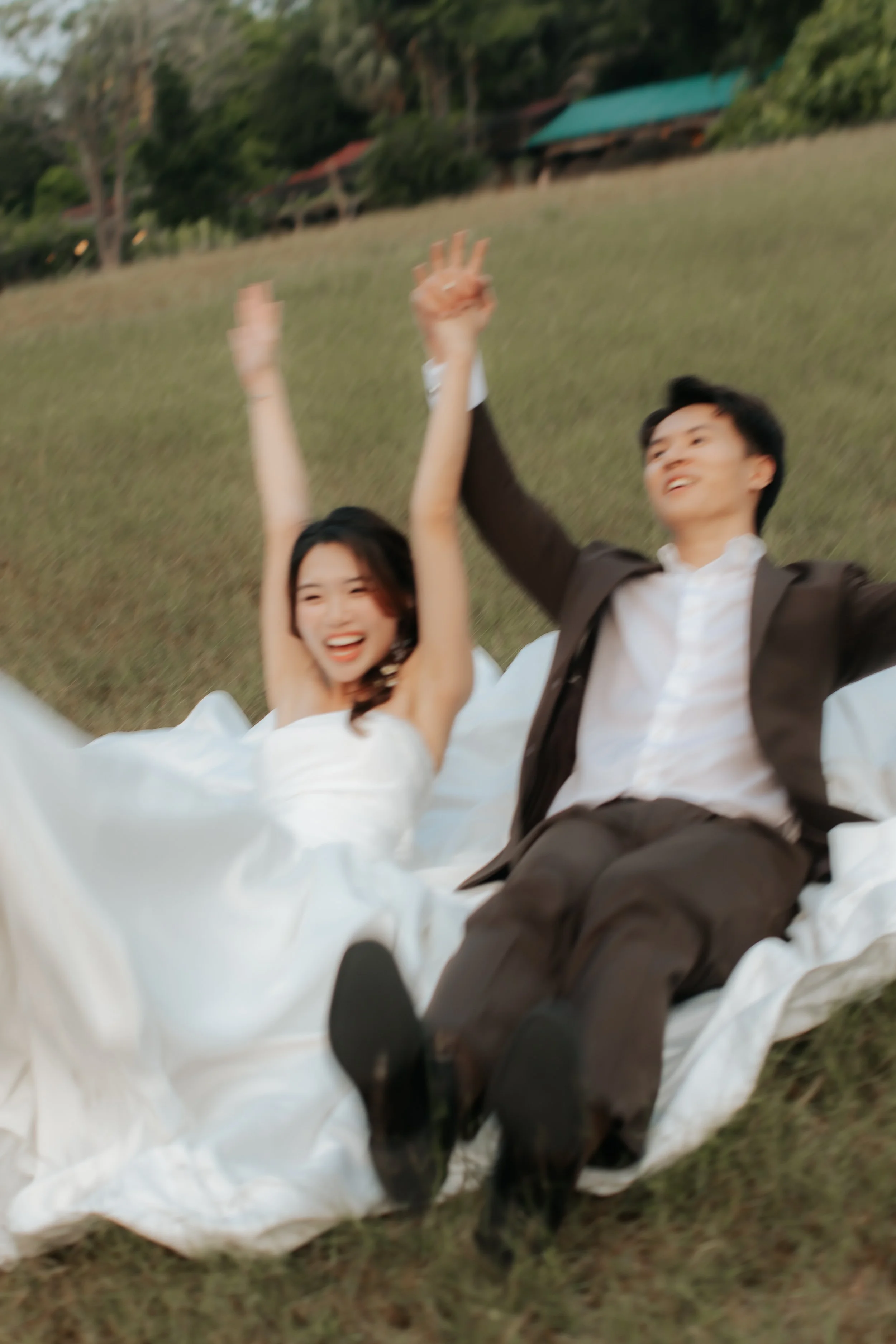 Romantic and dynamic pre-wedding photoshoot at Canterbury Hill. The couple is featured sliding down the hill at the end of their photoshoot. Captured in a light and airy style by Arielle from Breadandbutterworks.