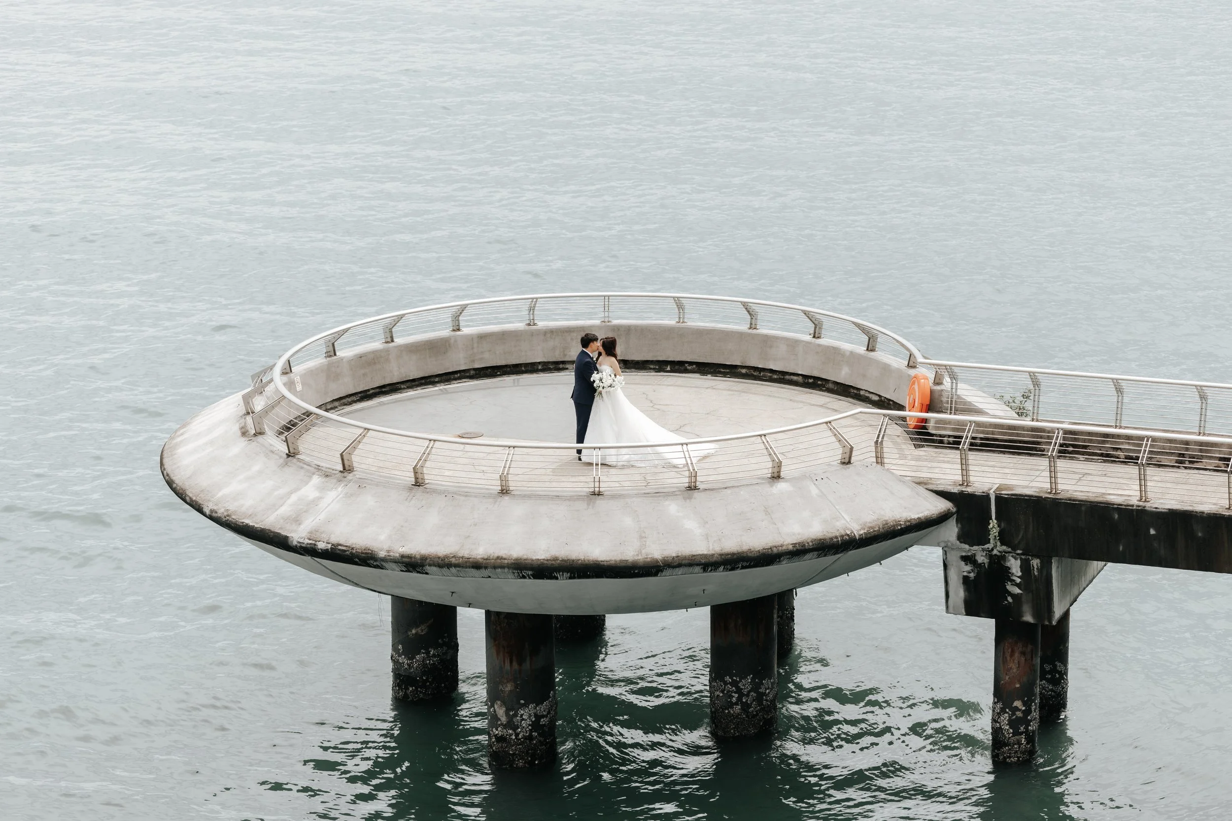 Cinematic actual day wedding photo of the bride and groom, this was captured along Marina Barrage by Breadandbutterworks in a soft and heartfelt style.