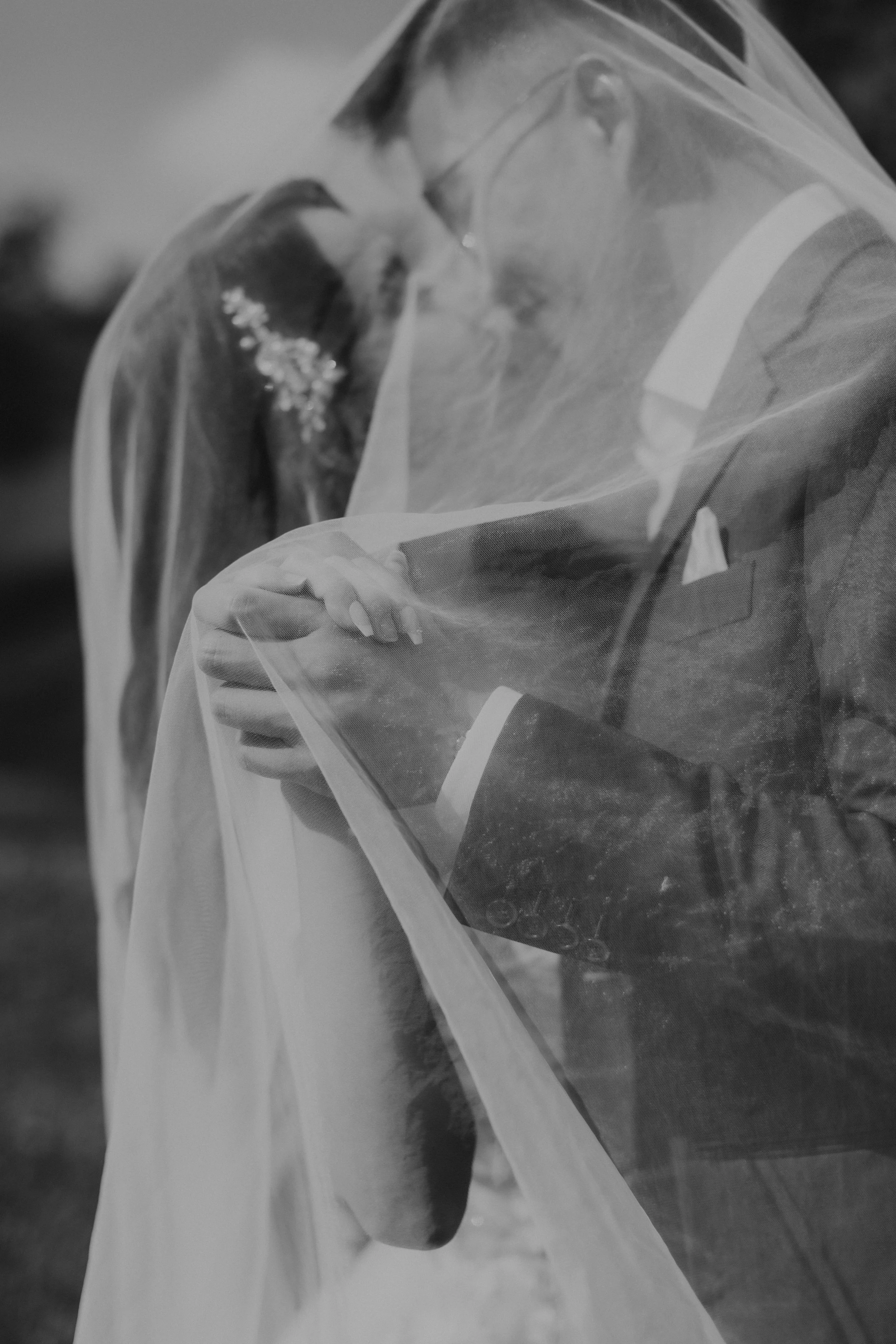 Creative black and white pre-wedding photoshoot at Arwaa Mansion, featuring an artistic close-up angle on the couple sharing a kiss beneath their bride's veil. Captured by Ash for Breadandbutterworks.