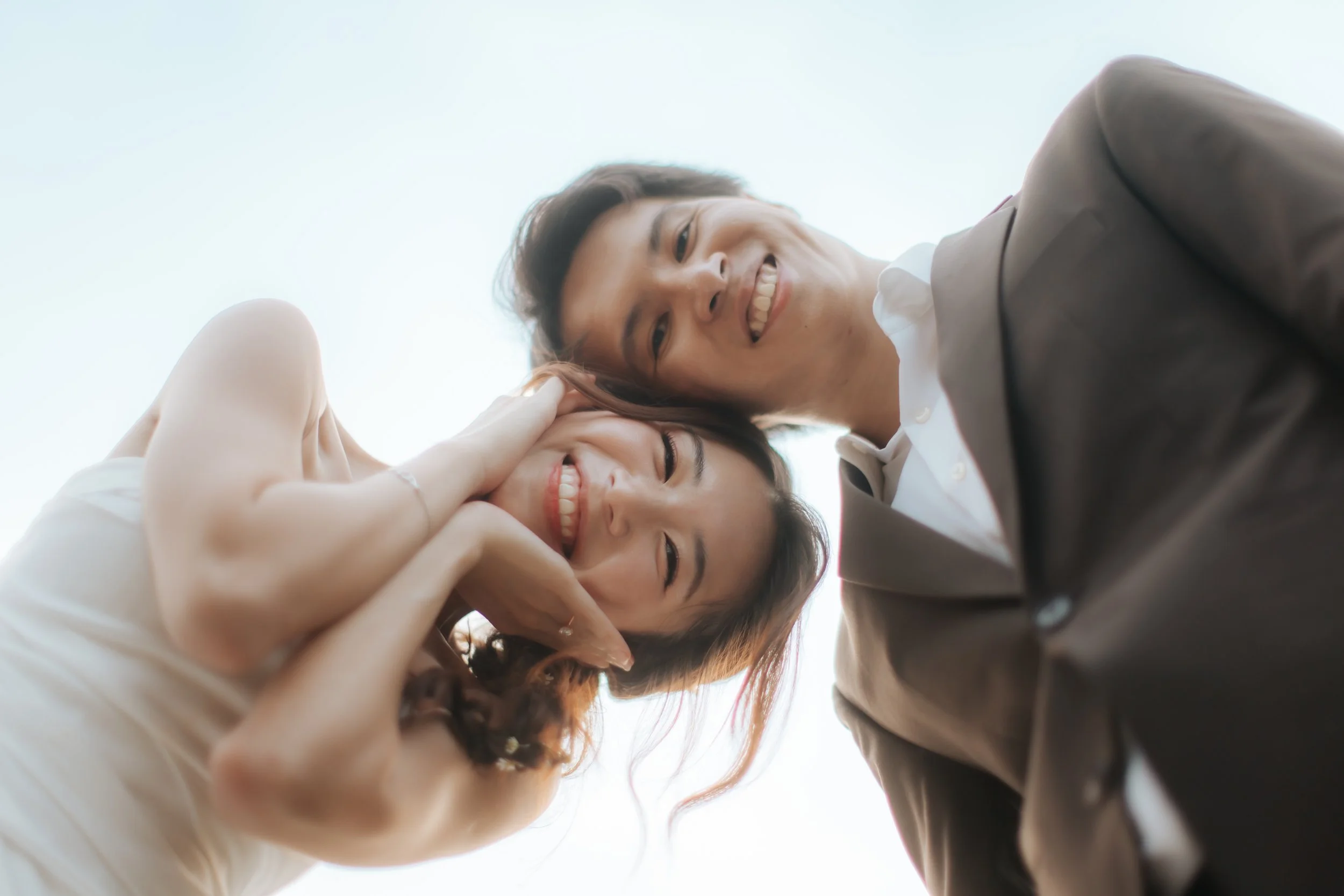 Cute pre-wedding photoshoot at Canterbury Hill. The couple poses for a low angle shot and they are smiling ear to ear. Captured in a light and airy style by Arielle from Breadandbutterworks.