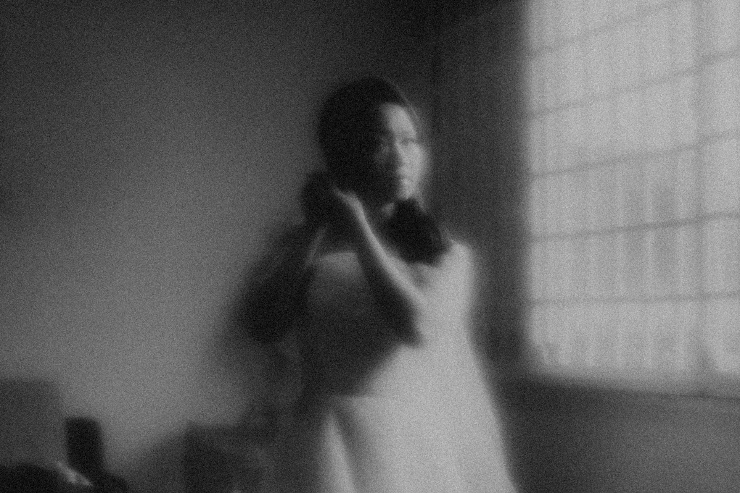Cinematic black and white portrait of a bride-to-be getting ready for her wedding day, captured by Breadandbutterworks.